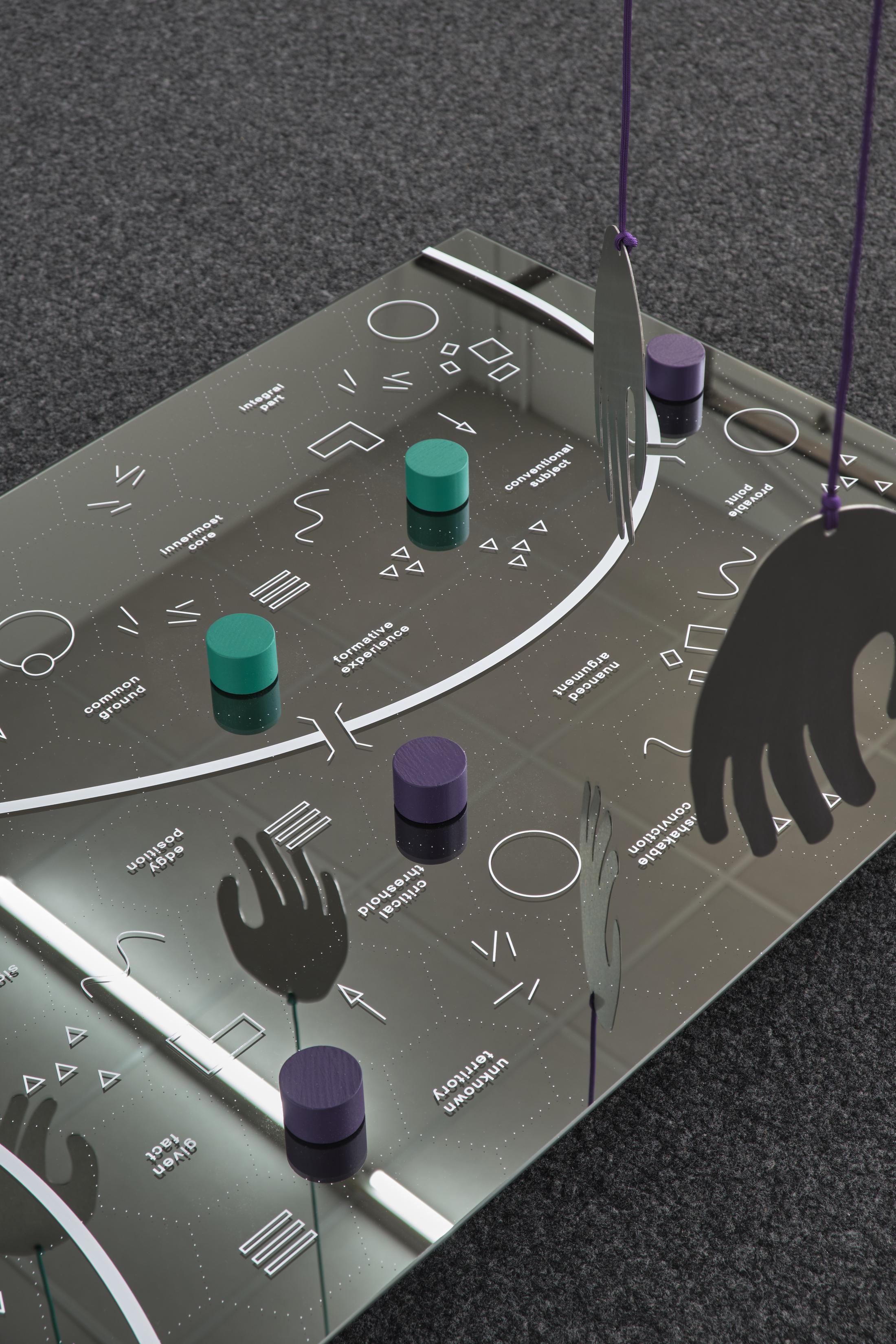 Exhibition View Philip Ullrich Solo Show «Remmidemmi in der Spielhölle (The Game Show); view on Philip Ullrich, at play (crossing a line), 2023, screen print on mirror, painted wood, metal, paracord mirror: 60 x 90 x 0.4 cm, with hands: dimensions variable» at unanimous consent, Zurich, 2023 / Photo: Philip Ullrich / Courtesy: the artist and unanimous consent