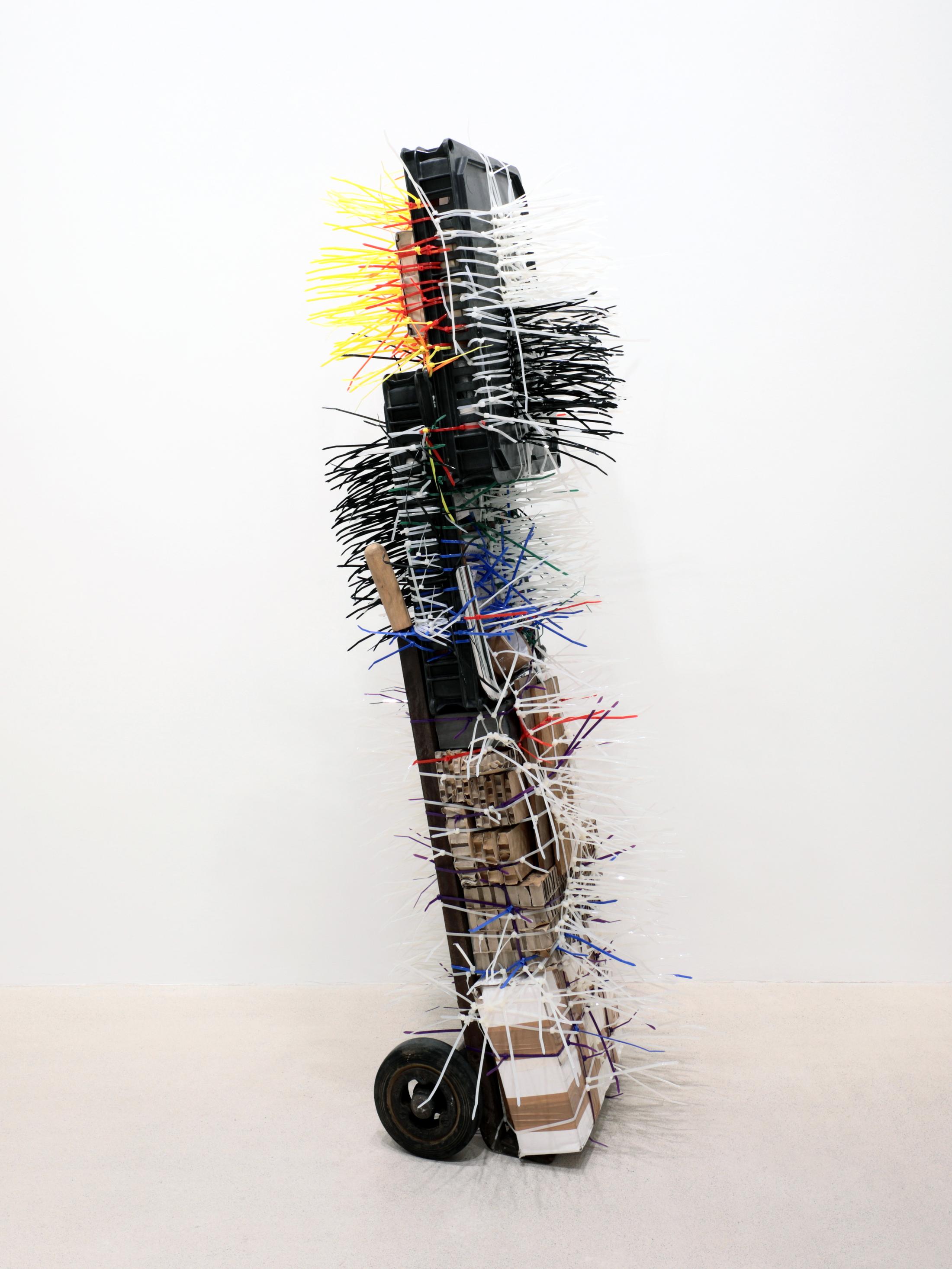 Exhibition View Umut Yasat Solo Show «35; view on Umut Yasat, Der Stapel 84, 2022, 175 x 58 x 72 cm, wood, plastic, steel, iron, ink, pencil, felt-tip pen, glue, tobacco, stainless steel, copper, cardboard, soil, aluminum, cotton, lime, water, whiskey, carbon dioxide, sugar, brass, E150d, E338, caffeine, silver, gold, tin, lithium, glass» at Windhager von Kaenel, Zurich, 2022 / Courtesy: the artist and Windhager von Kaenel