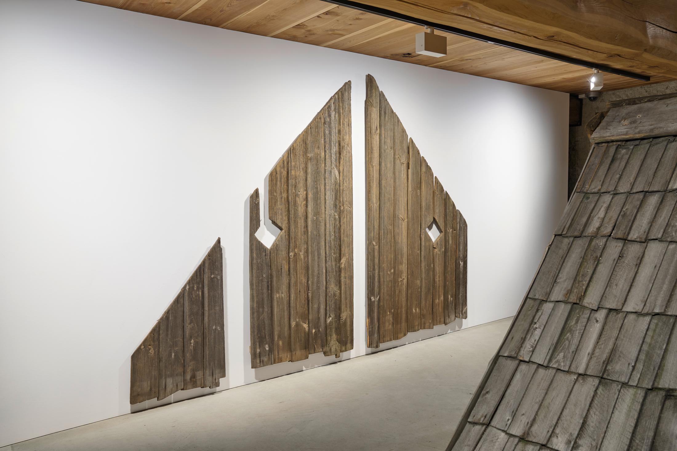 Exhibition View Augustas Serapinas Solo Show «Wood and Snow; view on Augustas Serapinas, Remains of the House from Skirgiškės, 2022, Reclaimed Wood, 370 x 480 x 500 cm» at Galerie Tschudi, Zuoz, 2022-2023 / Photo: Raphael Feiner / Courtesy: the artist and Galerie Tschudi