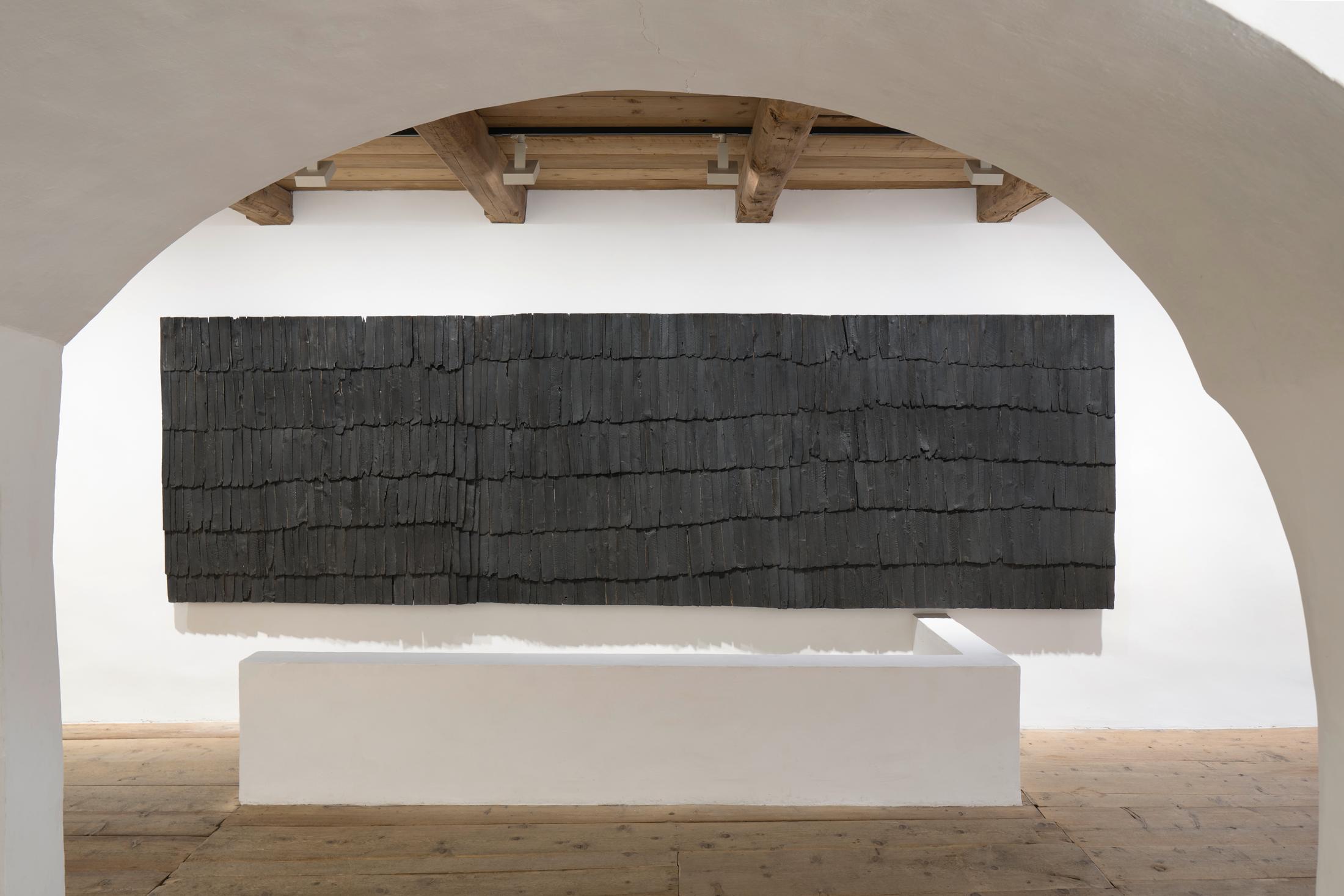 Exhibition View Augustas Serapinas Solo Show «Wood and Snow; view on Augustas Serapinas, Remains of the House from Skirgiškės, 2022, Reclaimed Wood, 370 x 480 x 500 cm» at Galerie Tschudi, Zuoz, 2022-2023 / Photo: Raphael Feiner / Courtesy: the artist and Galerie Tschudi