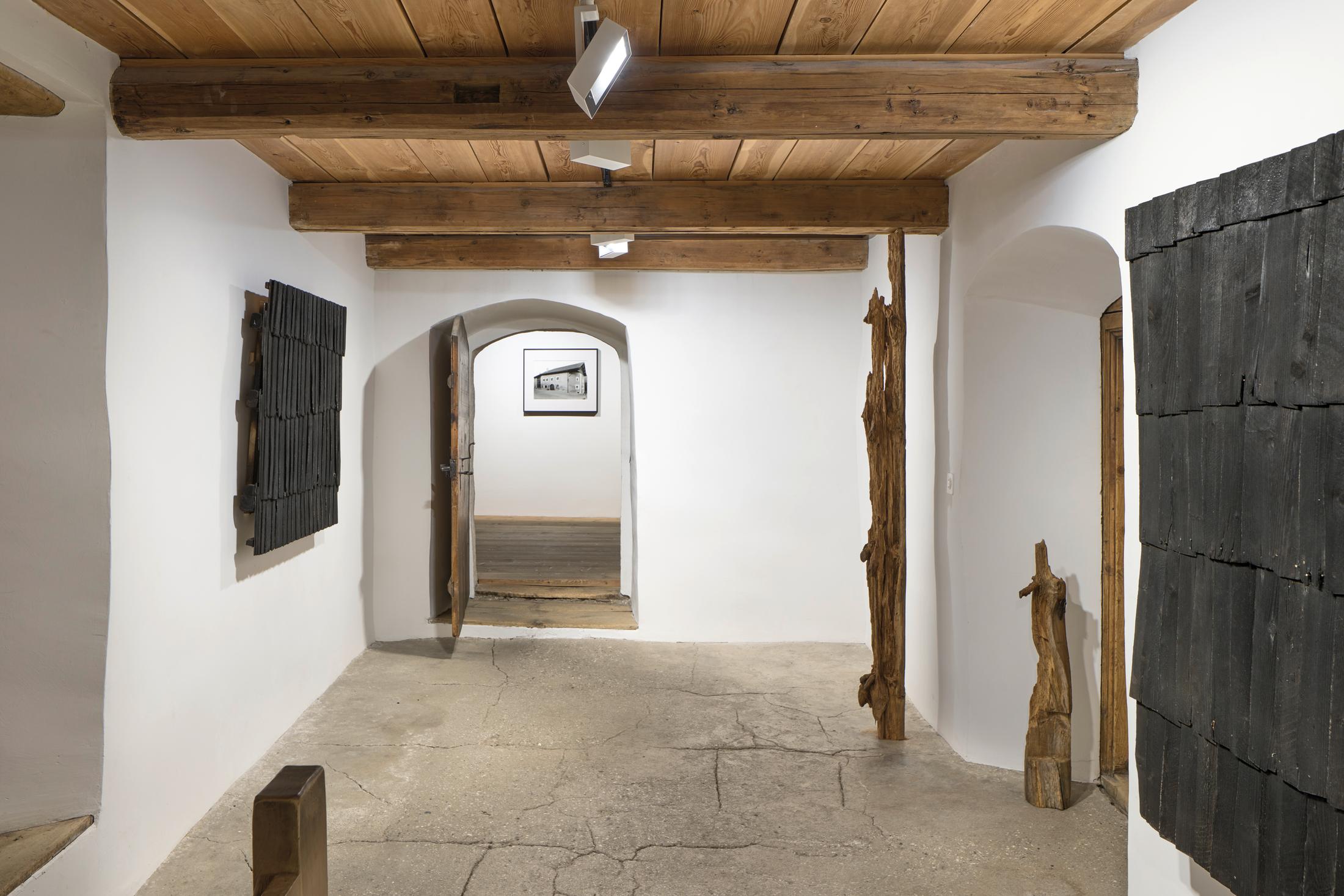 Exhibition View Augustas Serapinas Solo Show «Wood and Snow; view on Augustas Serapinas, Remains of the House from Skirgiškės, 2022, Reclaimed Wood, 370 x 480 x 500 cm» at Galerie Tschudi, Zuoz, 2022-2023 / Photo: Raphael Feiner / Courtesy: the artist and Galerie Tschudi