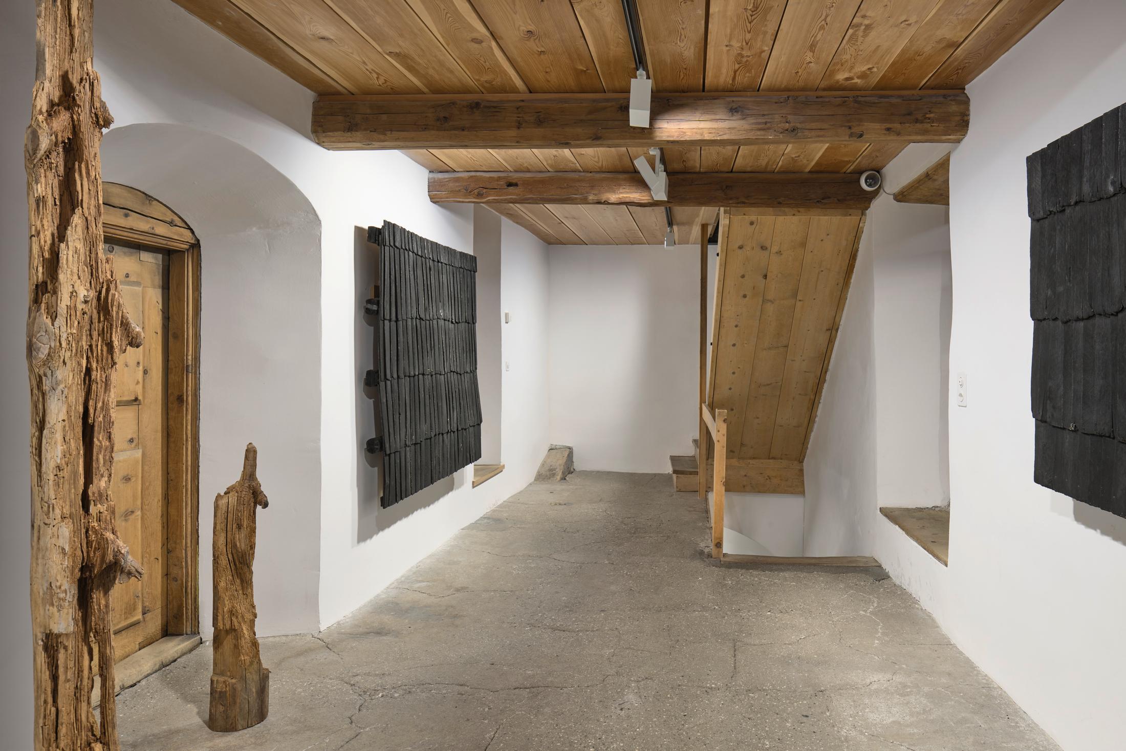 Exhibition View Augustas Serapinas Solo Show «Wood and Snow; view on Augustas Serapinas, Remains of the House from Skirgiškės, 2022, Reclaimed Wood, 370 x 480 x 500 cm» at Galerie Tschudi, Zuoz, 2022-2023 / Photo: Raphael Feiner / Courtesy: the artist and Galerie Tschudi