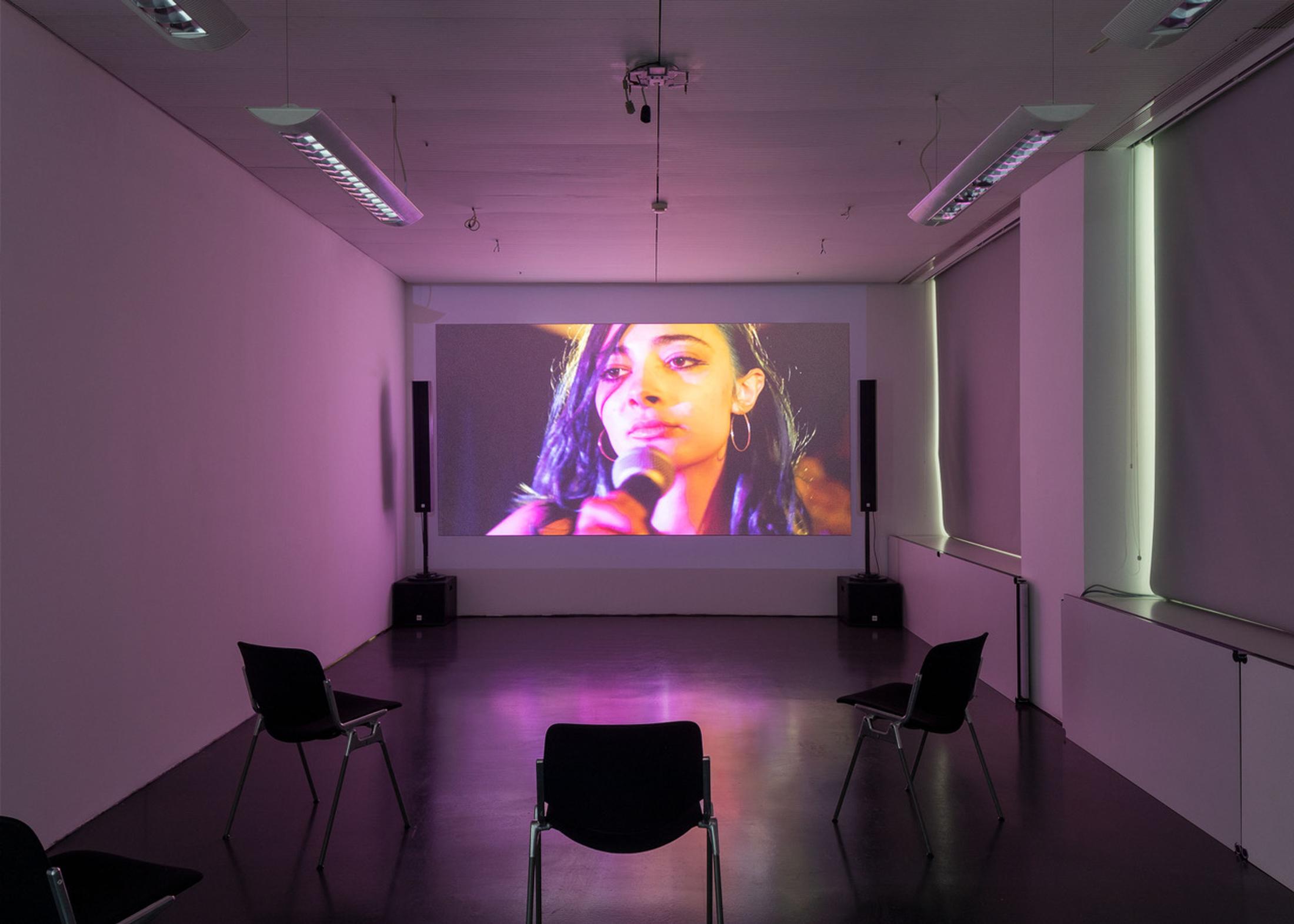 Exhibition View Beatrice Marchi and Mia Sanchez Duo Show «La Città e i Perdigiorno; view on Beatrice Marchi, The Photographer & The Friends (Nel Mondo Parallelo), 2021. Film still. HD digital video, sound, 15’38’’» at Istituto Svizzero, Milan, 2021 / Photo: Giulio Boem / Courtesy: artist and SANDY BROWN Berlin