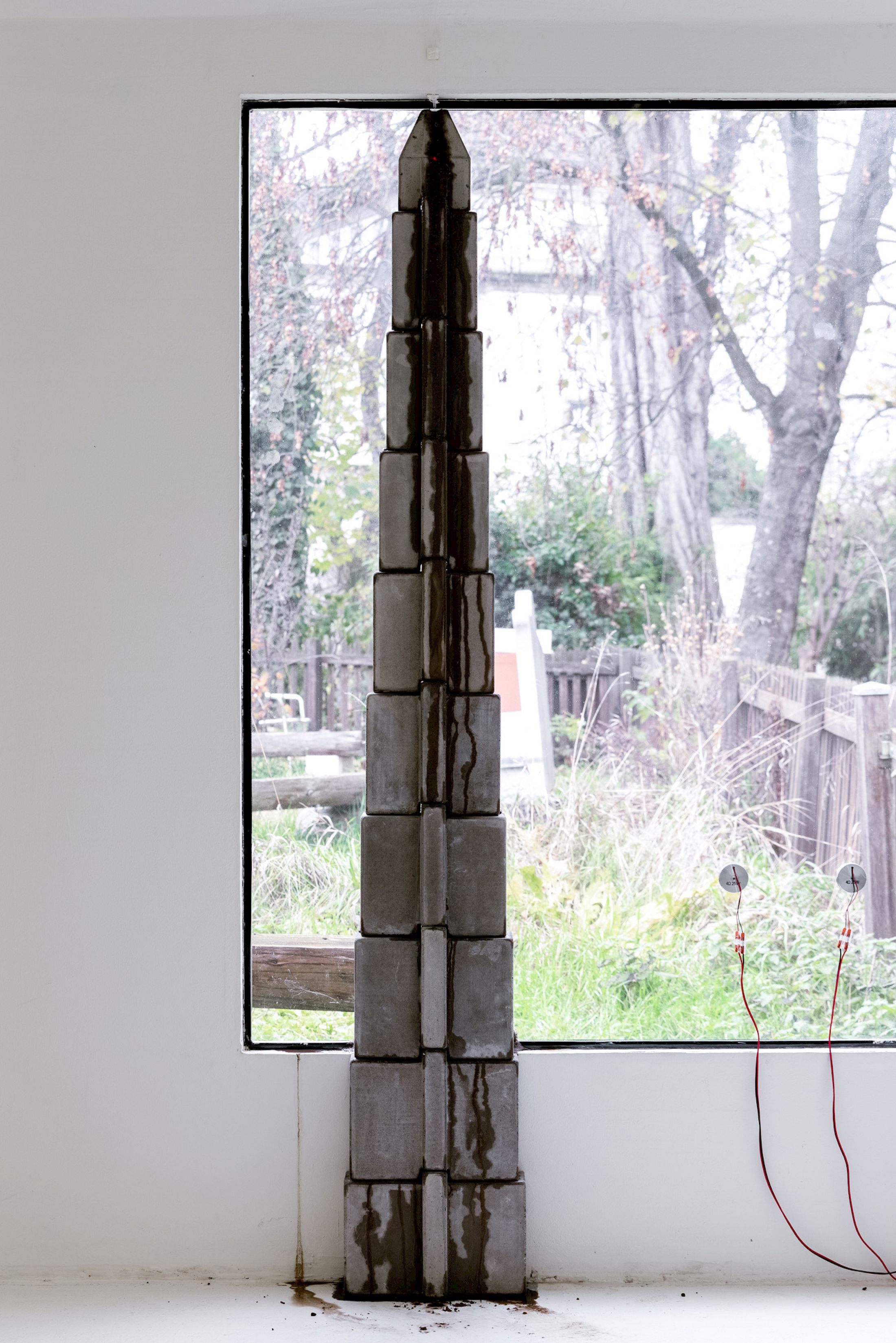 Exhibition View Solo Show Hunter Longe «Entgleitungen ; view on Dissolution of the State, 2025, concrete, hydrochloric acid, water, plastic tank, peristaltic pumps, silicone tubing, aquarium heaters, 197 x 24 x 15 cm (pumps, tank, tubing variable)» at City SALTS, Baselland, 2025-2026 / Photo: Nicolas Gysin / Courtesy: the artist and City SALTS