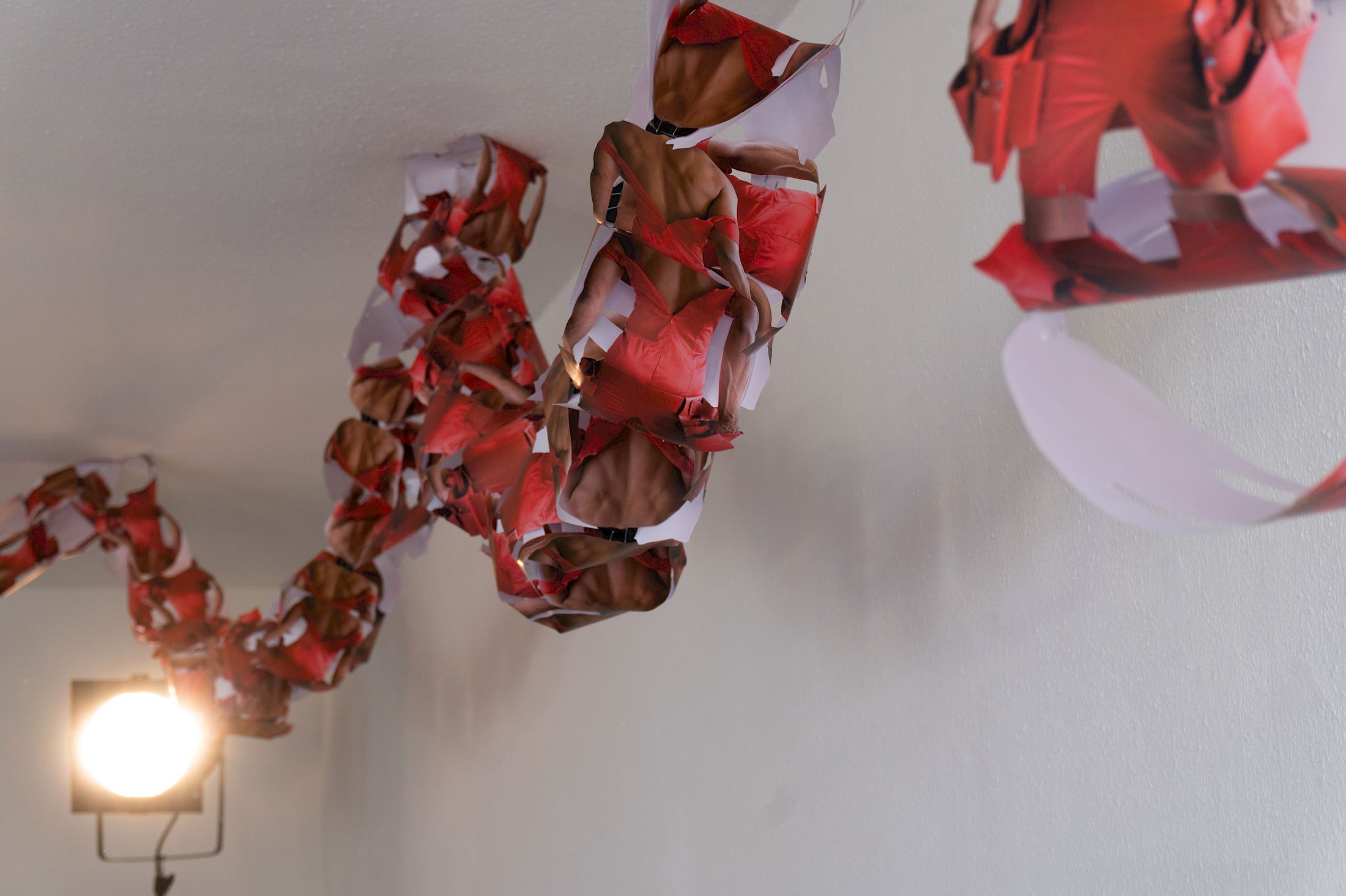 Exhibition View Solo Show Sven Gex «celebratory ; view on garland for ‚celebratory‘ (maid-of-all-work character), 2025, hand cut printed pictures, staples» at Halmet, Zurich-Oerlikon, 2025 / Photo: Tereza Glazova / Courtesy: the artist and Halmet