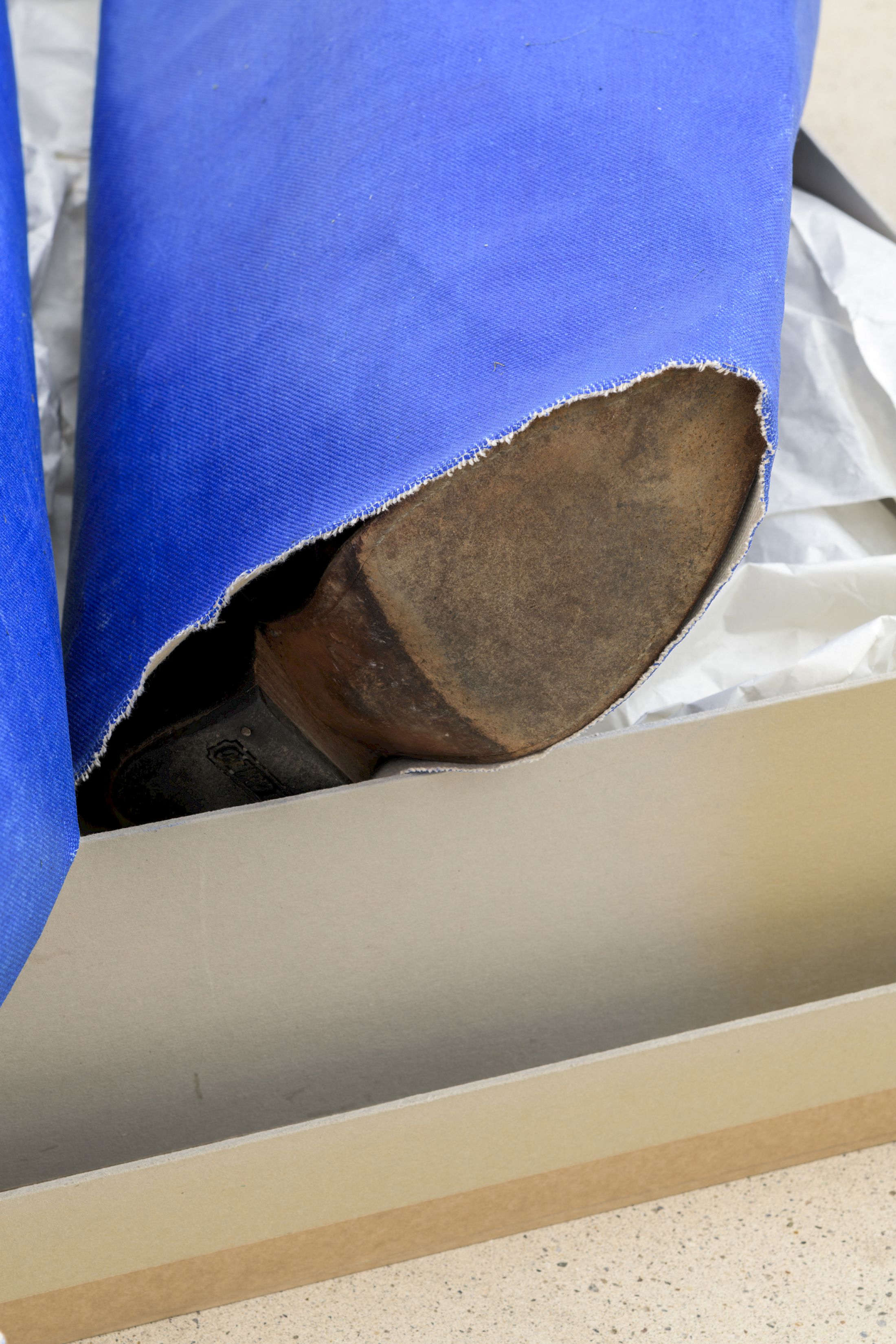 Exhibition View Solo Show Azize Ferizi «Fit In For Me ; view on Seasonal Labour (detail), 2025, oil on canvas, paper, cardboard, leather boots, 95 x 70 x 30cm» at Windhager Von Kaenel, Zug, 2025 / Photo: Julian Blum / Courtesy: the artist and Windhager von Kaenel