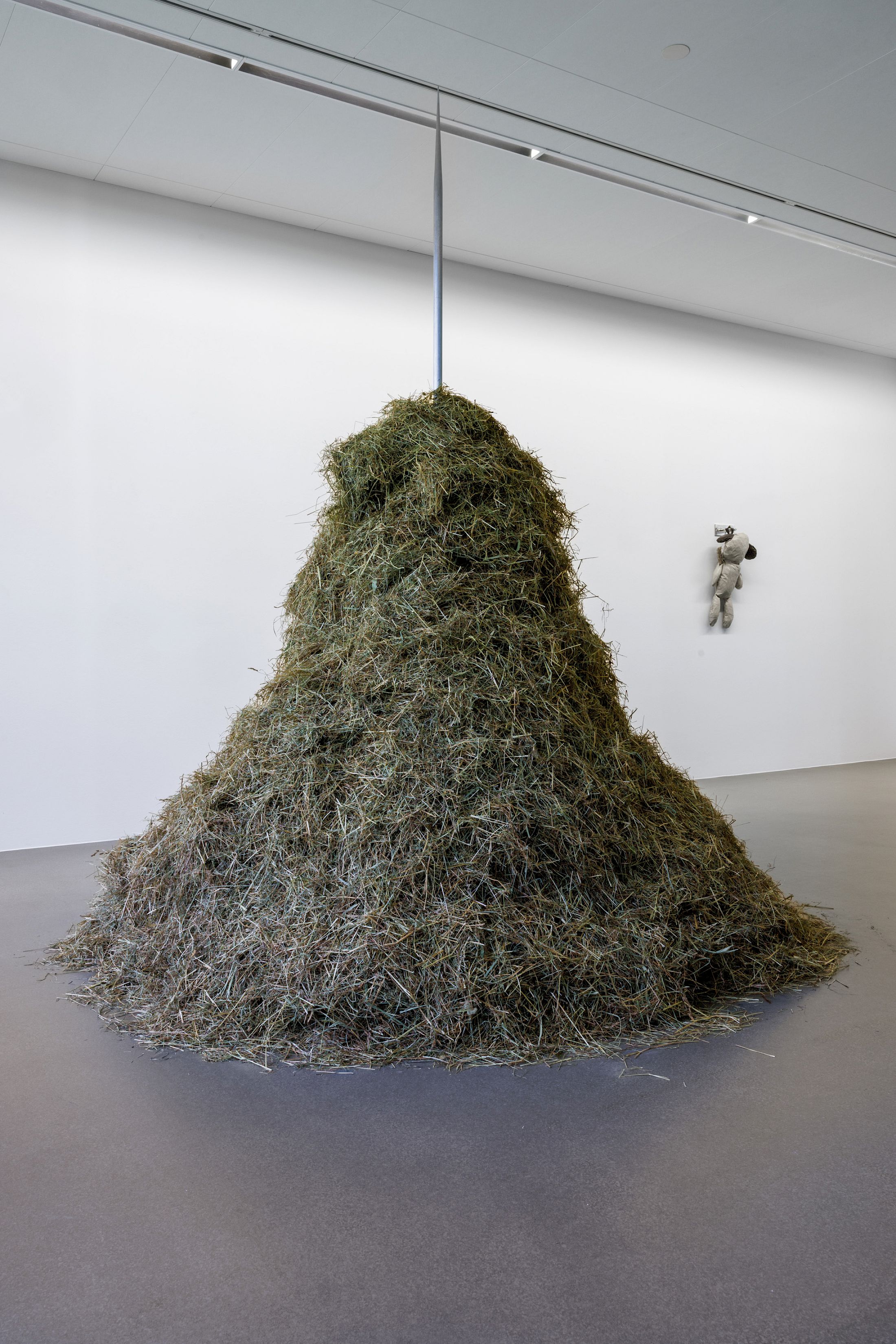 Exhibition View Dorota Gawęda & Eglė Kulbokaitė Solo Show «Death by Landscape; view on Dorota Gawęda & Eglė Kulbokaitė, Hexanol (IV), 2020, polished steel, meadow hay, 230 x 100 x 96 cm and Kratt, 2021, recycled leather, hay, chromed steel fixtures, dimensions variable» at Haus für Kunst Uri, Altdorf, 2025 / Photo: Franz-Xaver Brun / Courtesy: the artists and Haus für Kunst Uri