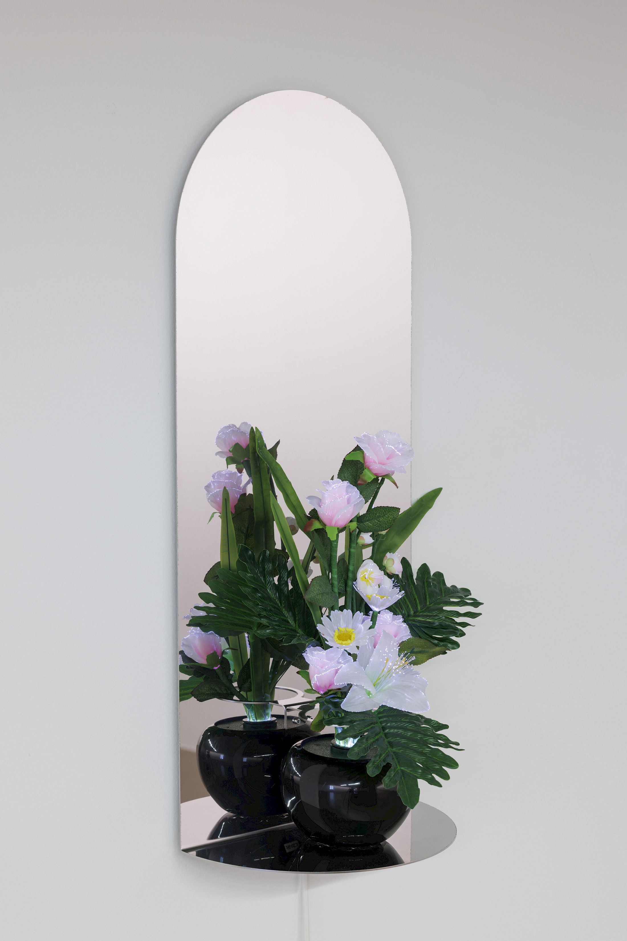 Exhibition View Dorota Gawęda & Eglė Kulbokaitė Solo Show «Death by Landscape; view on Dorota Gawęda & Eglė Kulbokaitė, Votive Flowers II, 2022, lightbulb, optical fibres, paper and plastic flowers, electric cable, colour gel disc and rotating mechanism, mirror polished stainless steel. 68 x 36 x 18 cm» at Haus für Kunst Uri, Altdorf, 2025 / Photo: Franz-Xaver Brun / Courtesy: the artists and Haus für Kunst Uri