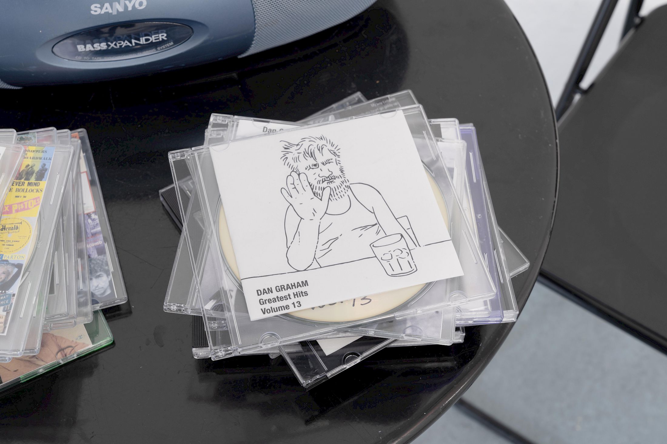 Exhibition View Group Show «Ecstatic Trance: Artists on Rock My Religion ; view on Dan Graham, Dan Graham’s Greatest Hits (detail), Volume 1 - 21 + The Kinks, 2004–2022/2025, 22 compact discs and inkjet prints» at marytwo, Luzern, 2025-2026 / Photo: Jack Pryce / Courtesy: The Dan Graham and Mieko Graham Foundation