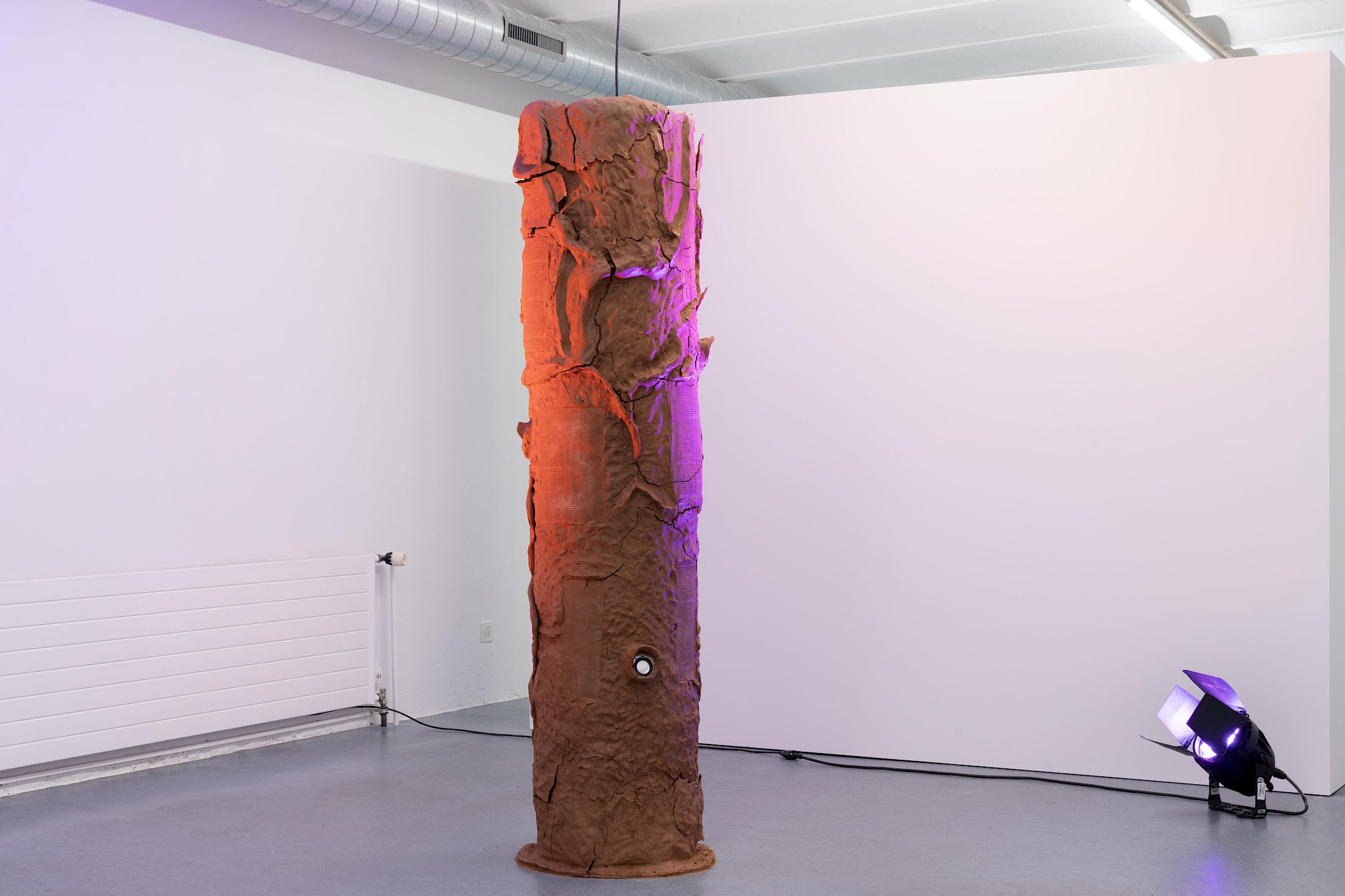 Exhibition View Group Show «Ecstatic Trance: Artists on Rock My Religion ; view on Ashton Phillips, Authority Complex (Mold me. Hold me. Take me. Break me. Use me for your pleasure. Be not afraid.), 2025, Clay, wire, burlap, steel, wool, stage lights, 4-channel sound work, 195 × 47 cm» at marytwo, Luzern, 2025-2026 / Photo: Jack Pryce / Courtesy: the artist and marytwo