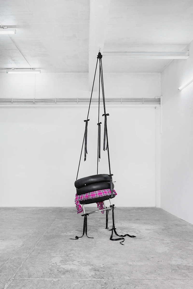 Exhibition View Solo Show Lauryn Youden «I wanna hold the hand inside you ; view on Would you die tonight for love?, 2025, Bibendum Chair (1926), pink plaid skirt, black ribbons, black mooring line, heart locket necklace with red hair, 3x handforged nails, 370 × 93 × 77 cm (suspended)» at CIRCUIT, Lausanne, 2025 / Photo: Aude Mayer / Courtesy: the artist and CIRCUIT