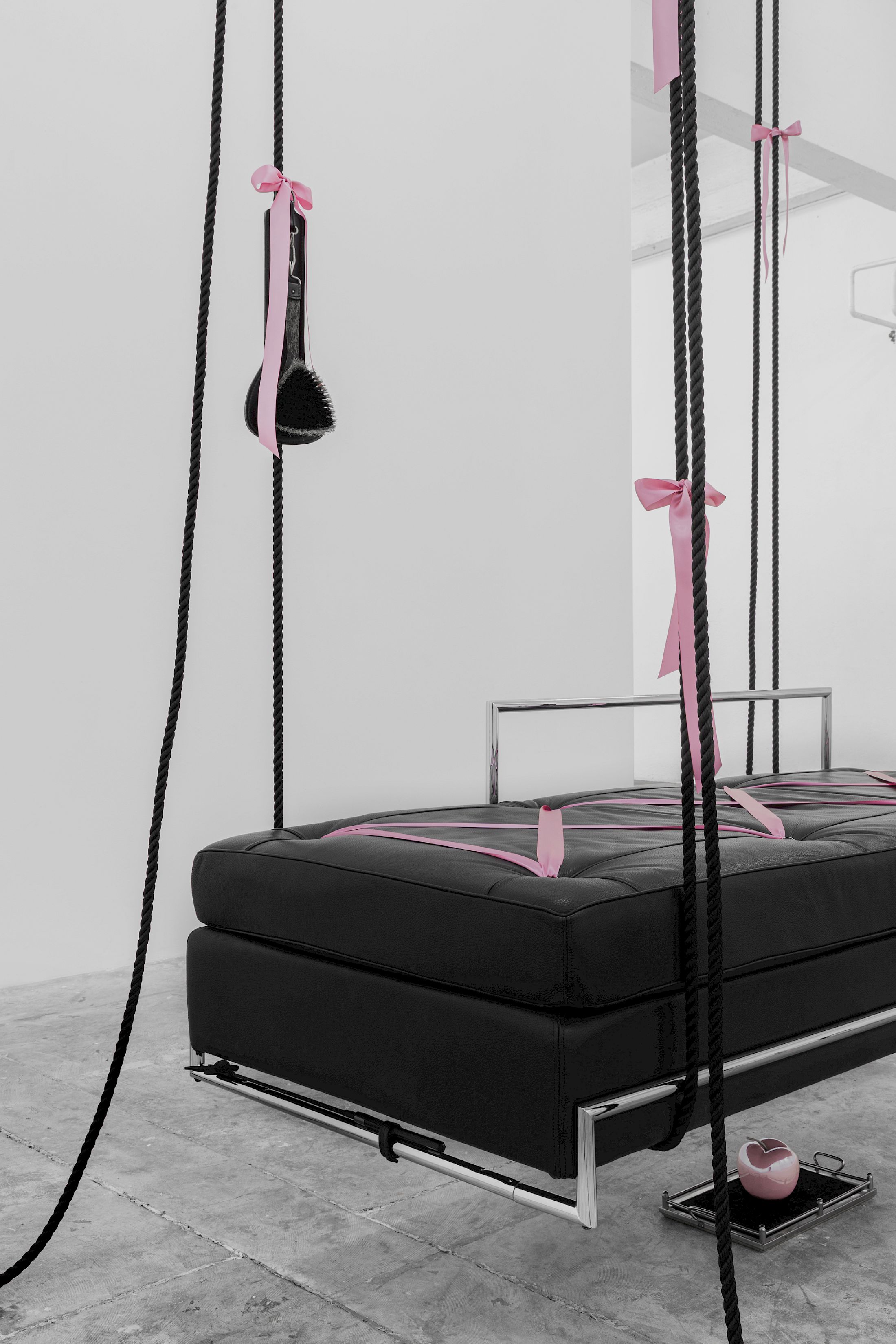 Exhibition View Solo Show Lauryn Youden «I wanna hold the hand inside you ; view on siège d'amour (Edward VII)(Detail), 2025, Day Bed (c. 1925), pink porcelain apple, velvet tray, rose ribbons, black mooring line, book: Bob Flanagan’s The Pain Journal, vintage lesbian BDSM photograph, horse hair brush, butterfly riding crop, 450 × 192 × 85 cm (suspended)» at CIRCUIT, Lausanne, 2025 / Photo: Aude Mayer / Courtesy: the artist and CIRCUIT