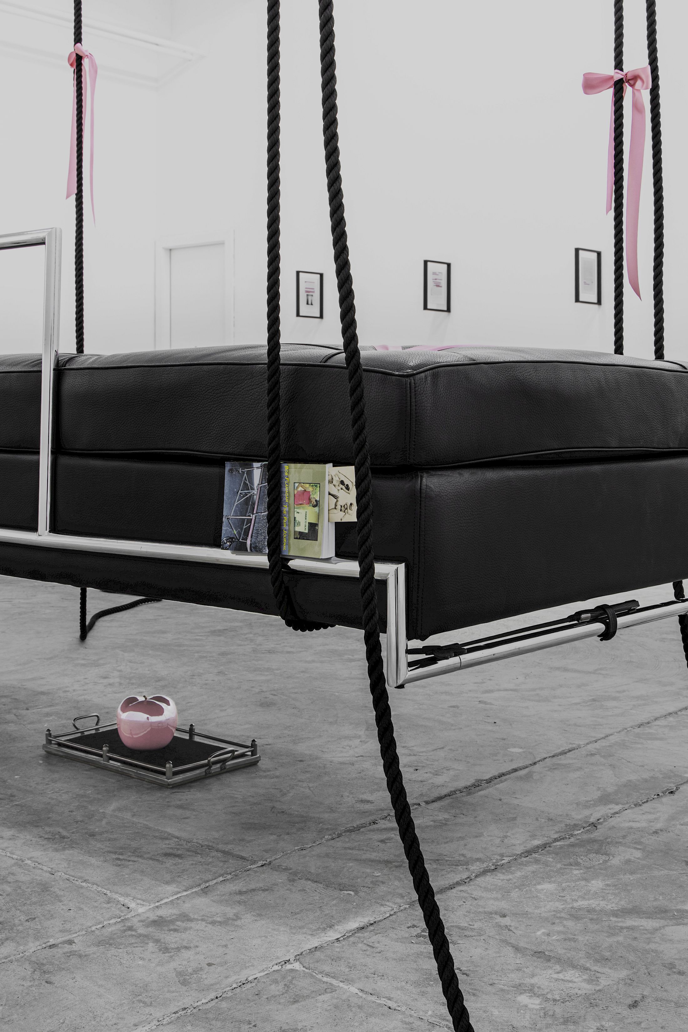 Exhibition View Solo Show Lauryn Youden «I wanna hold the hand inside you ; view on siège d'amour (Edward VII)(Detail), 2025, Day Bed (c. 1925), pink porcelain apple, velvet tray, rose ribbons, black mooring line, book: Bob Flanagan’s The Pain Journal, vintage lesbian BDSM photograph, horse hair brush, butterfly riding crop, 450 × 192 × 85 cm (suspended)» at CIRCUIT, Lausanne, 2025 / Photo: Aude Mayer / Courtesy: the artist and CIRCUIT
