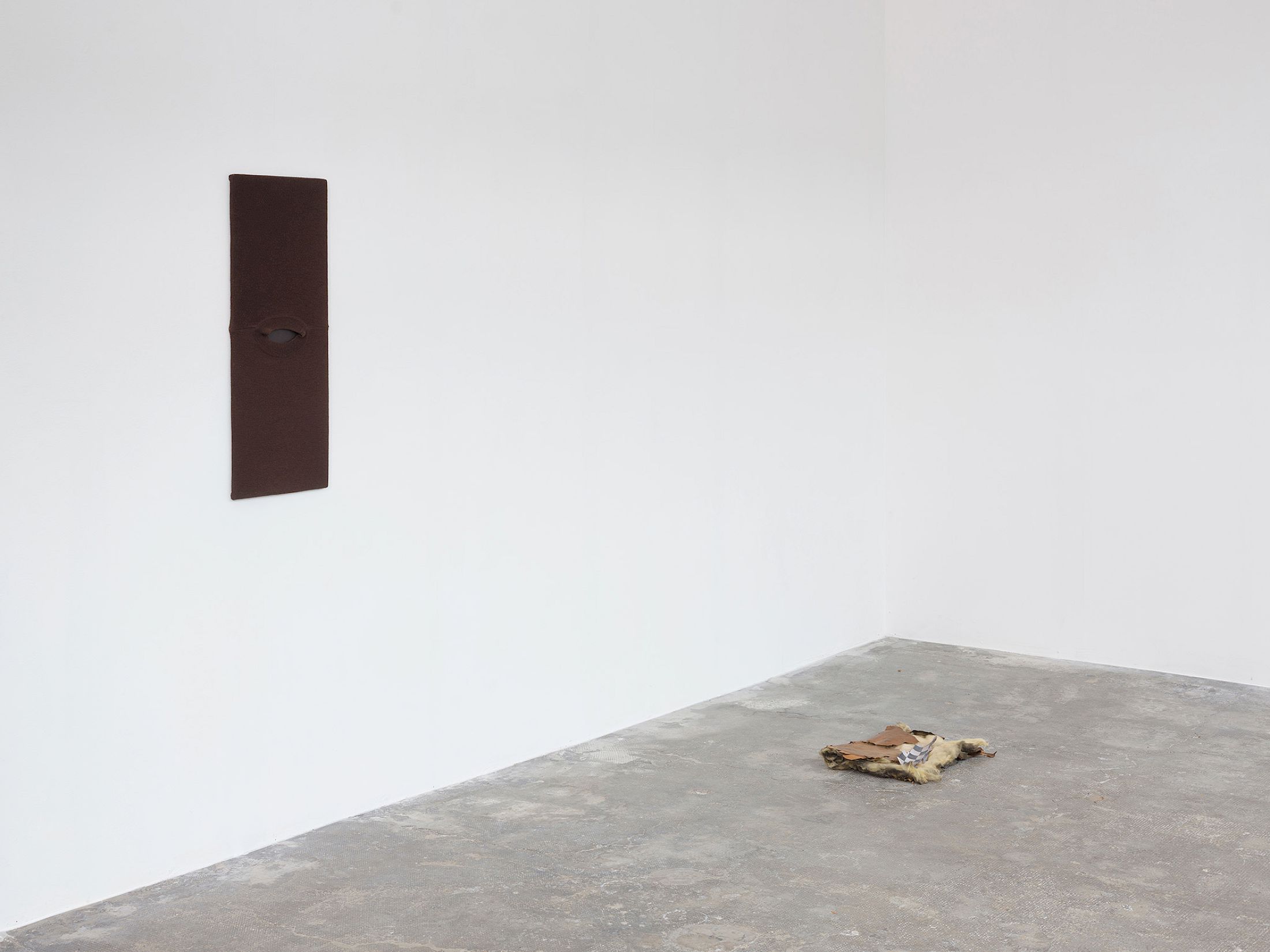 Exhibition View Group Show «Long distance relationship ; view on Hélène Janicot, Untitled, 2025, pullover, wood, 80 × 32cm ; Untitled, 2025, insulation foam, photograph on bark, 45 × 35cm» at Smallville, Neuchâtel, 2025 / Photo: Sebastien Verdon / Courtesy: the artists and Smallville