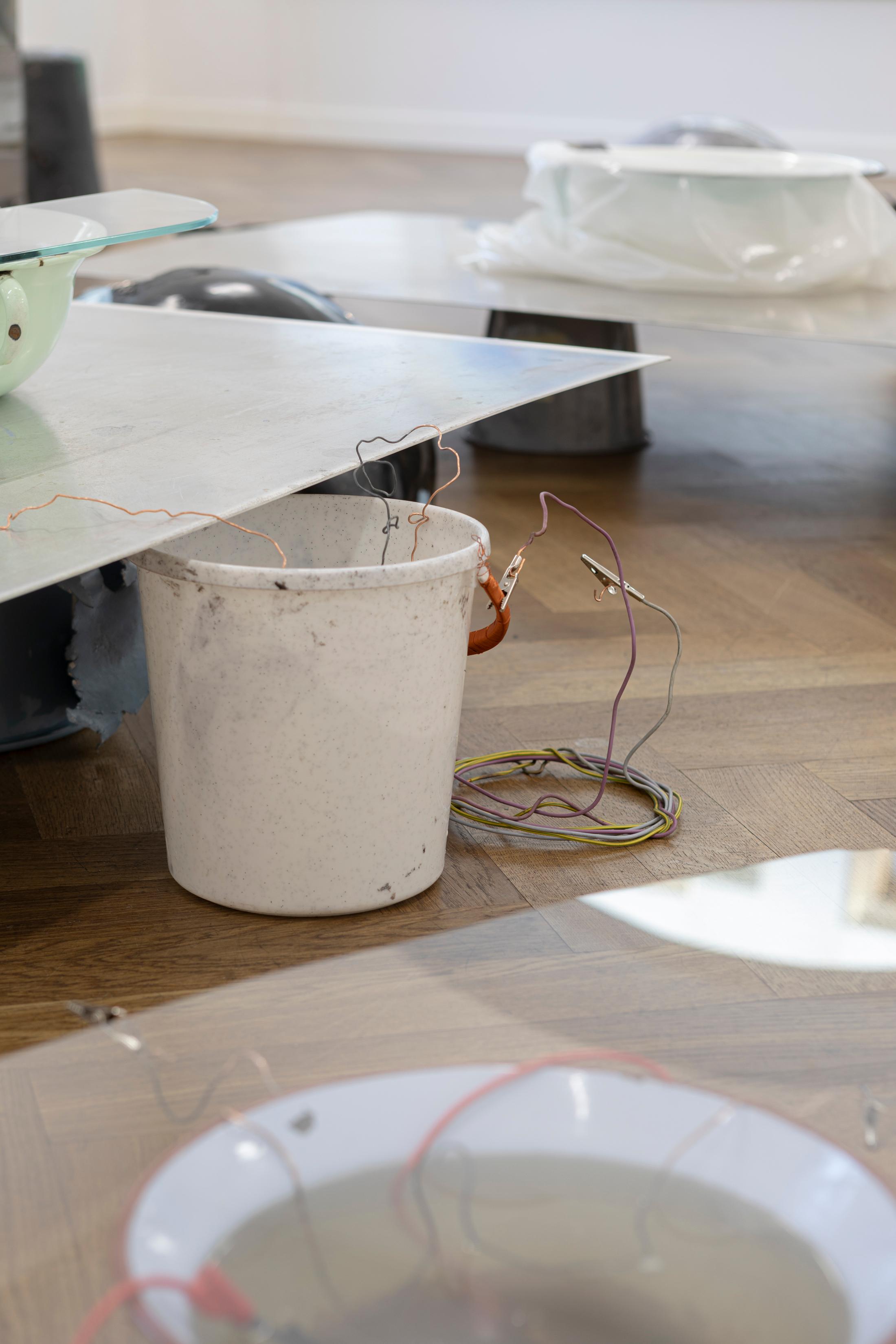 Exhibition View Solo Show Julia Znoj «BASS MY TRESPASS ; view on Setup (Direct Current) (detail), 2025, laboratory power supply, zinc electrolyte, water, paint, steel, aluminum, paper, glue, glass, wire, found objects, size variable» at Krone Couronne, Biel/Bienne, 2025 / Photo: Michal Schorro / Courtesy: the artist and Krone Couronne