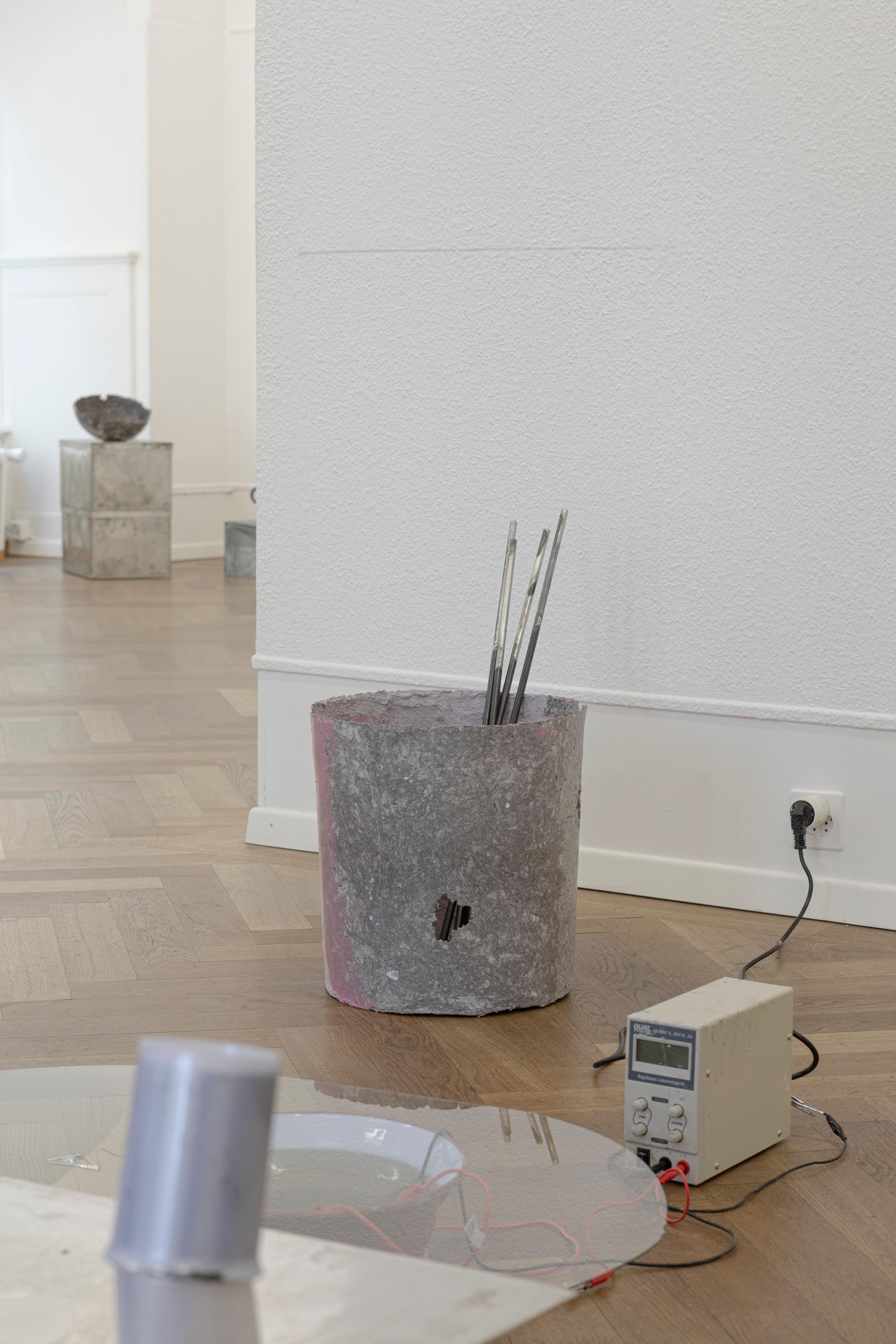 Exhibition View Solo Show Julia Znoj «BASS MY TRESPASS ; view on Setup (Direct Current) (detail), 2025, laboratory power supply, zinc electrolyte, water, paint, steel, aluminum, paper, glue, glass, wire, found objects, size variable» at Krone Couronne, Biel/Bienne, 2025 / Photo: Michal Schorro / Courtesy: the artist and Krone Couronne
