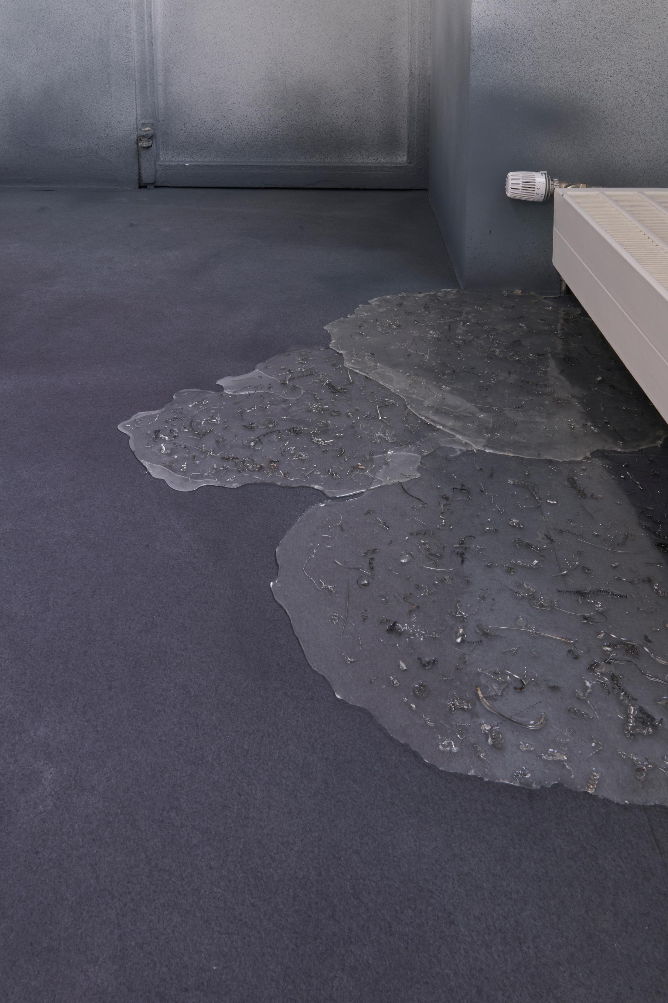 Exhibition View Duo Show Marlène Charpentié and Sophie Conus «DOWN THE RABBIT HOLE; view on (Sol) Pond of Tears, 2024, Carpet, resin, paint, metallic leftovers, found objects, 14m35 x 6m68» at Halle Nord, Geneva, 2024 / Photo: Thomas Maisonnasse / Courtesy: the artists and Halle Nord