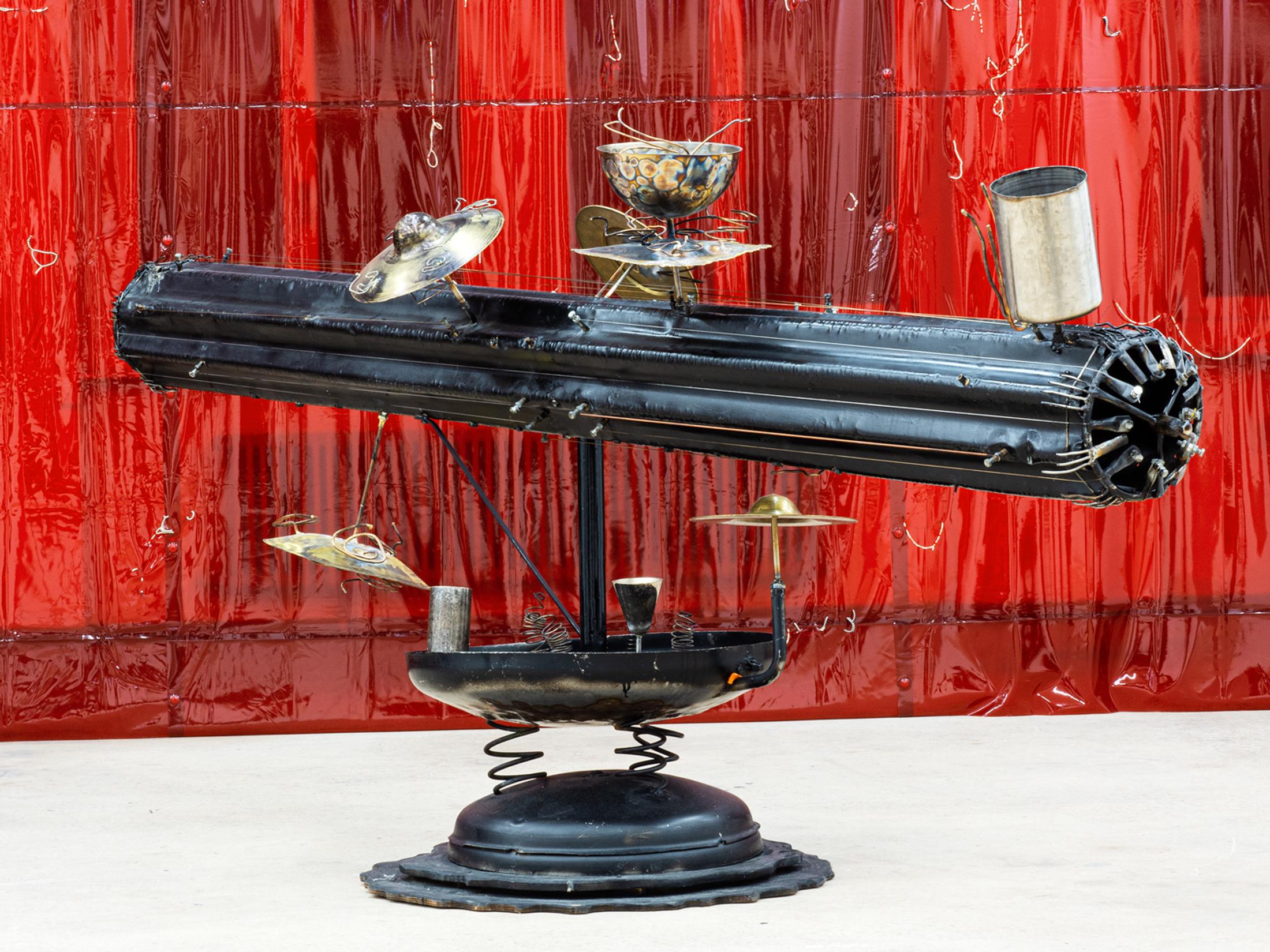 Exhibition View Double Show Martin Andereggen «Self Storage ; view on Untitled (The long lasting cult of the eccentric),  PVC protective curtains, neodym magnets, printed image,  24 × 3 m, 2024» and Martin Spühler «Kosmos ; view on Streichelkanone,  Metall, 145 × 300 × 85 cm» at Kunstraum Kreuzlingen, Kreuzlingen, 2024-2025 / Photo: Martin Andereggen / Courtesy: the artists and Kunstraum Kreuzlingen