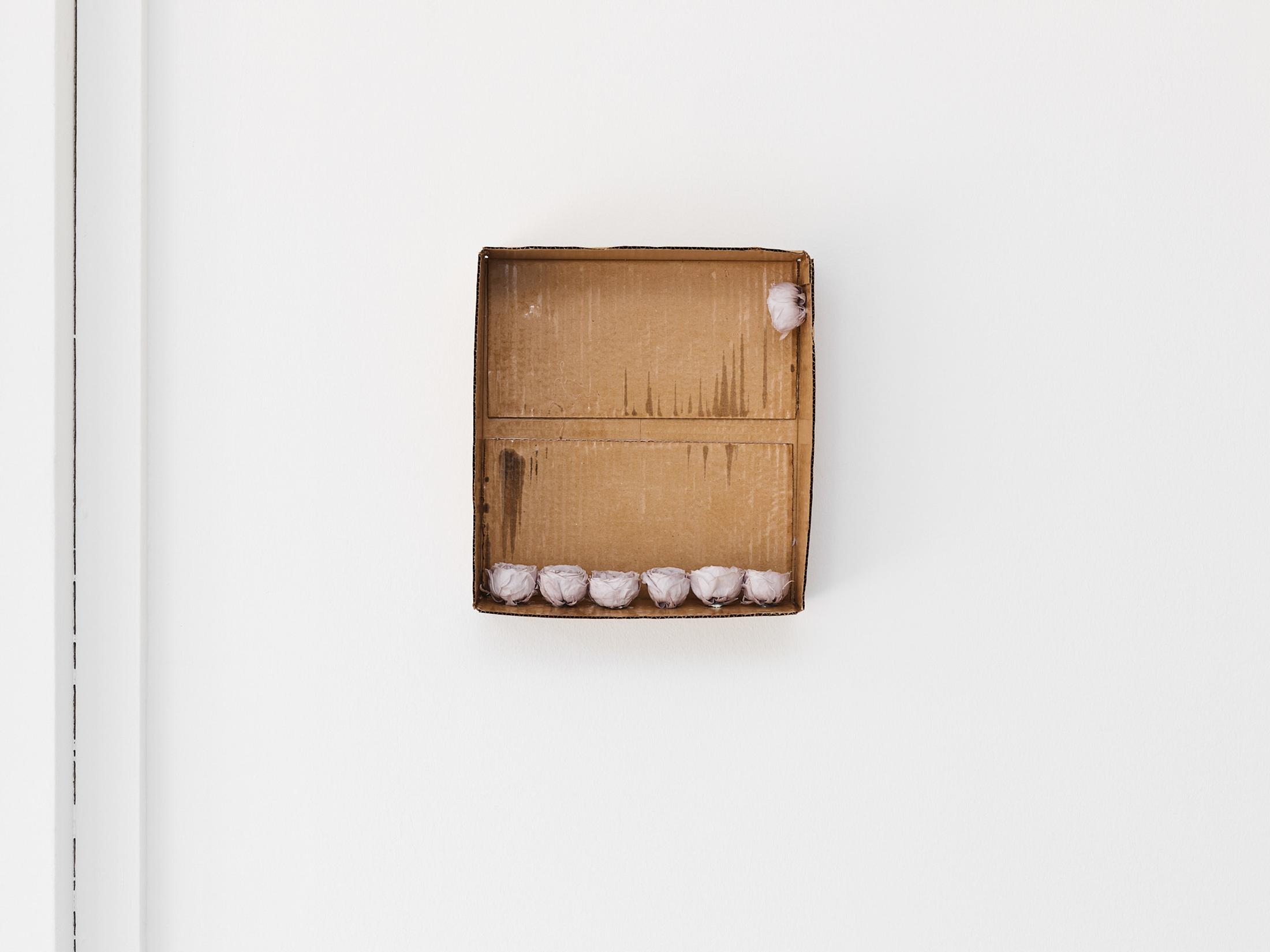 Exhibition View Gina Folly Solo Show «Dolce Vita; view on Gina Folly, Don’t look at your phone first thing in the morning, 2023, box, varnished cardboard, seven stabilized grey
roses, 34 x 31 x 9 cm» at Centre d'édition contemporaine, Geneva, 2023 / Photo: Sandra Pointet / Courtesy: the artist and Centre d'édition contemporaine