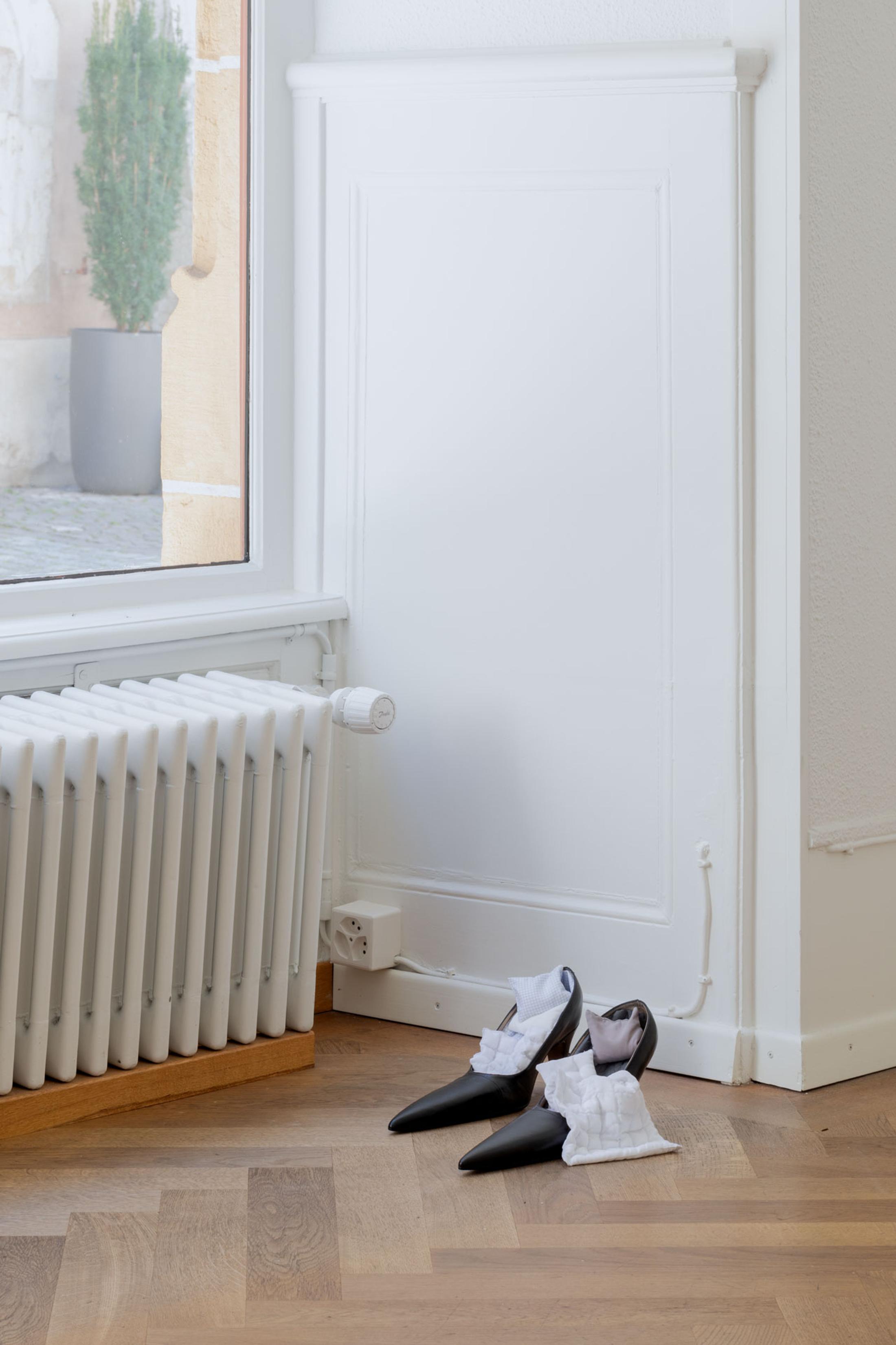 Exhibition View Leolie Greet with Amélie Bodenmann, Anina Müller and Nina Rieben Show «mumbles slide along the sleeve; view on Nina Rieben, Sidelines in a corner of potentiel, 2023, modified heel shoes, textile objects» at Krone Couronne, Biel, 2023 / Photo: Guadalupe Ruiz / Courtesy: the artist and Krone Couronne