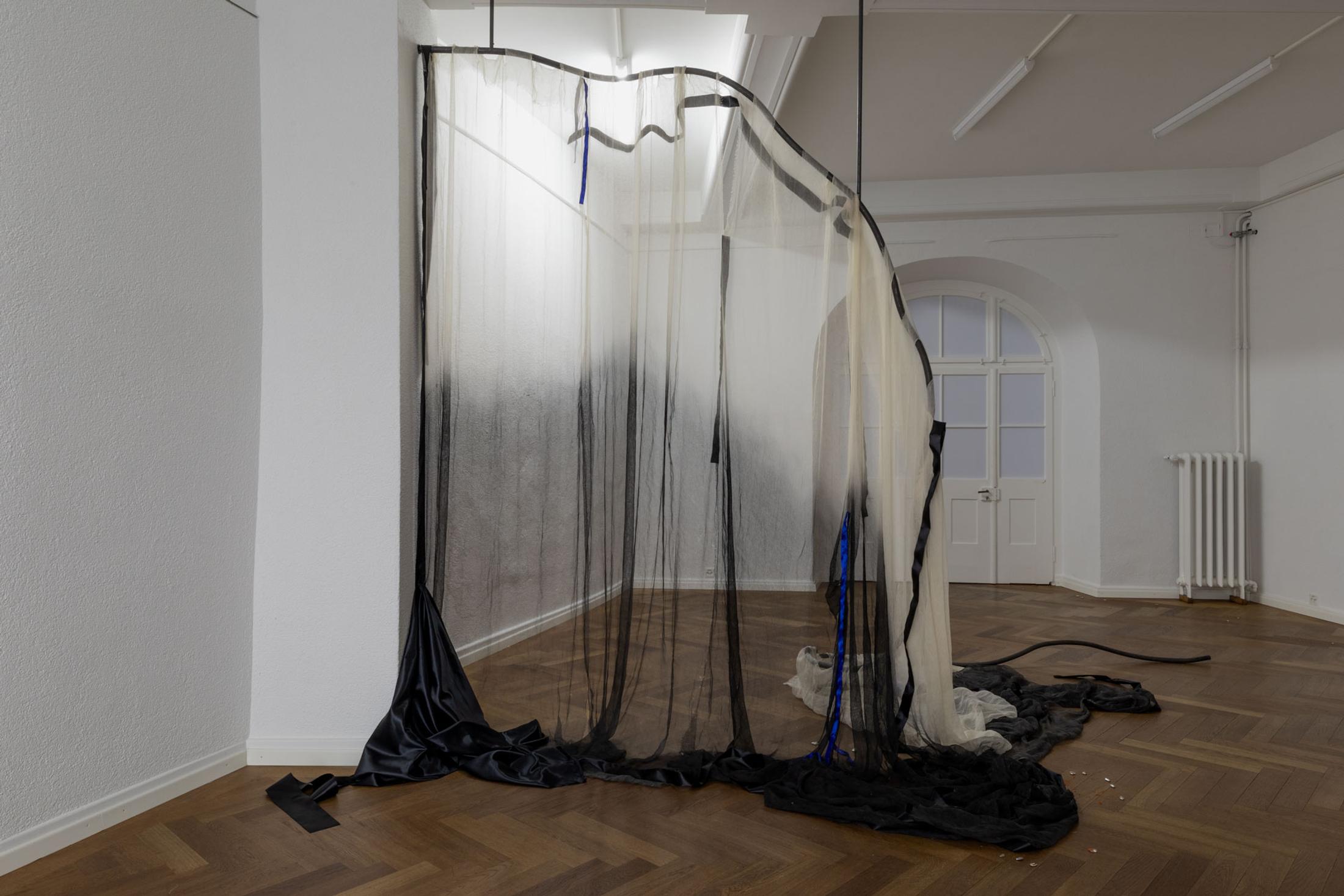 Exhibition View Leolie Greet with Amélie Bodenmann, Anina Müller and Nina Rieben Show «mumbles slide along the sleeve; view on Leolie Greet, whether to fold or bow, 2023, steel, cotton, ink, satin, sewing
thread» at Krone Couronne, Biel, 2023 / Photo: Guadalupe Ruiz / Courtesy: the artist and Krone Couronne