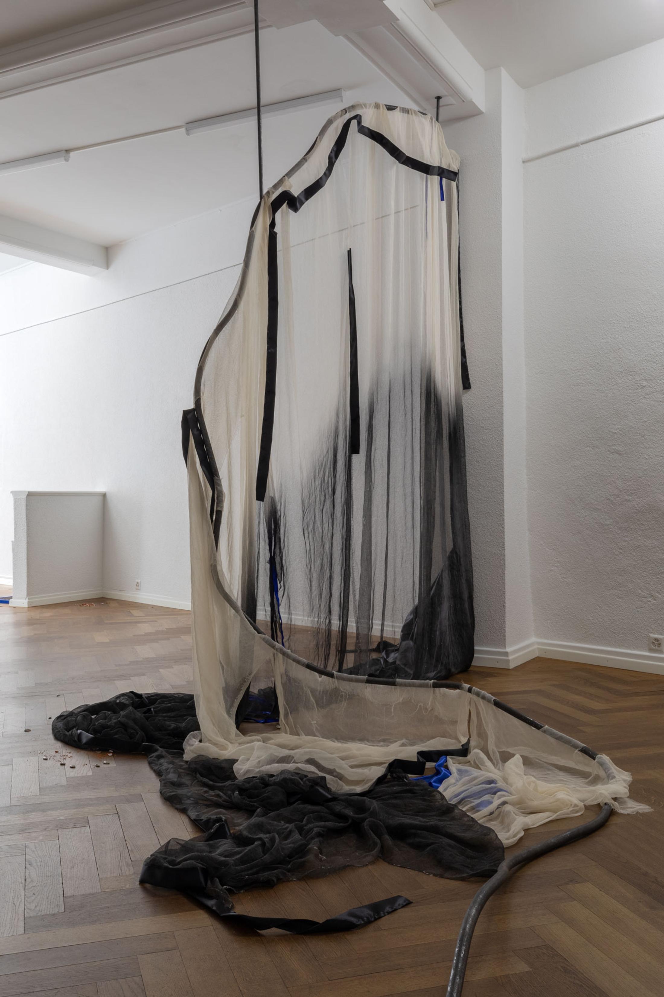 Exhibition View Leolie Greet with Amélie Bodenmann, Anina Müller and Nina Rieben Show «mumbles slide along the sleeve; view on Leolie Greet, whether to fold or bow, 2023, steel, cotton, ink, satin, sewing
thread» at Krone Couronne, Biel, 2023 / Photo: Guadalupe Ruiz / Courtesy: the artist and Krone Couronne