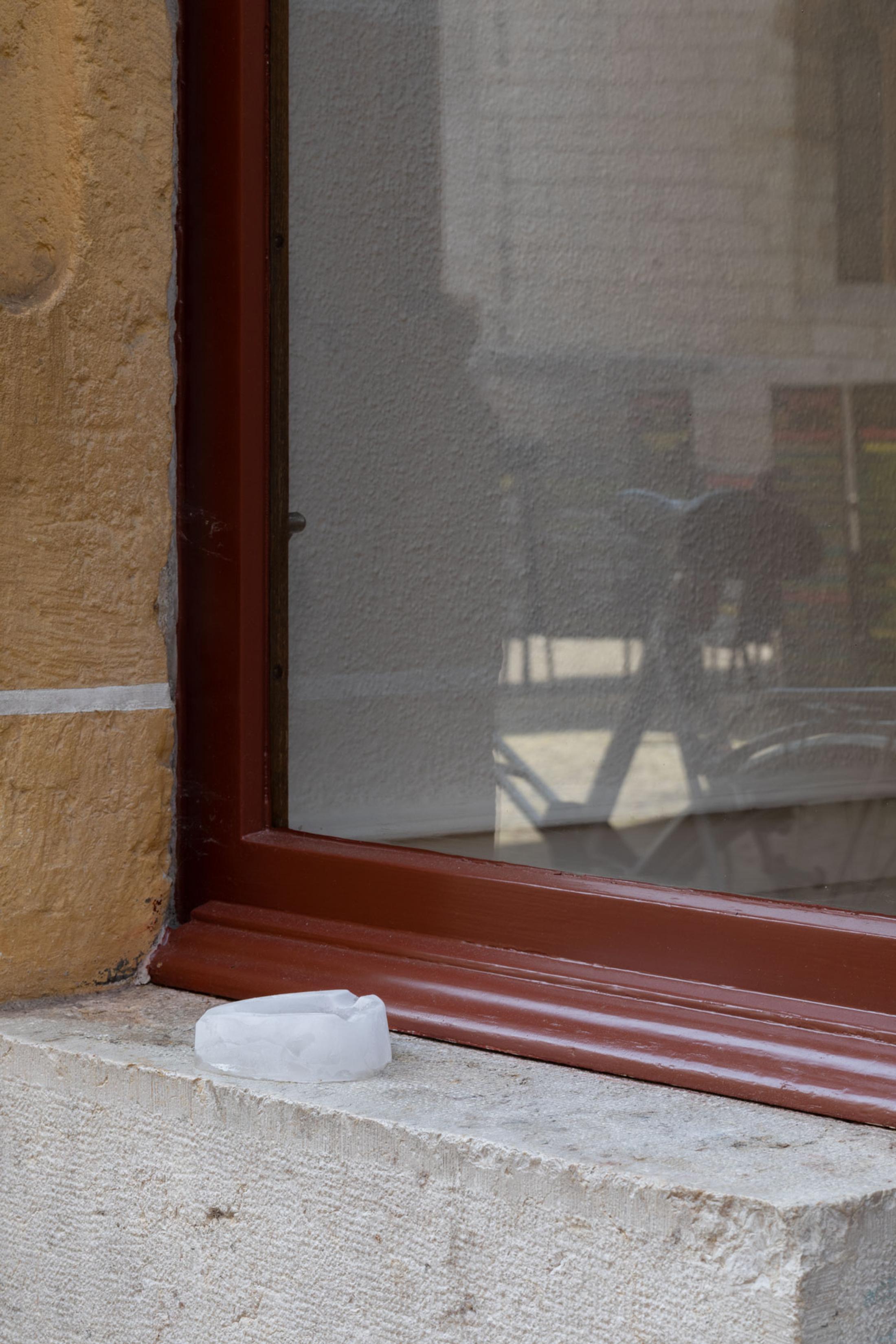 Exhibition View Leolie Greet with Amélie Bodenmann, Anina Müller and Nina Rieben Show «mumbles slide along the sleeve; view on Amélie Bodenmann, Ashtray, glaces, 2023, ice, replaced everyday» at Krone Couronne, Biel, 2023 / Photo: Guadalupe Ruiz / Courtesy: the artist and Krone Couronne