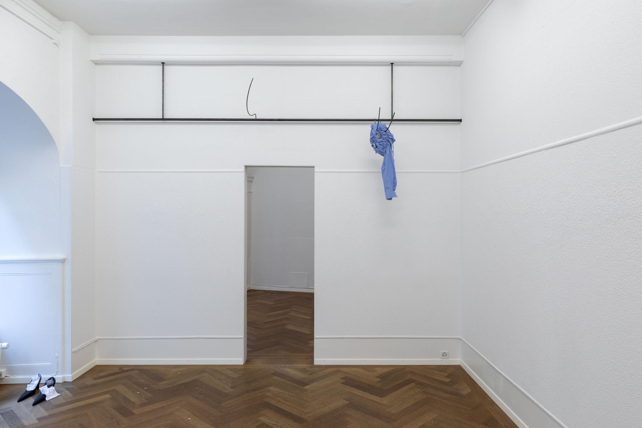 Exhibition View Leolie Greet with Amélie Bodenmann, Anina Müller and Nina Rieben Show «mumbles slide along the sleeve; view on Leolie Greet, feelings nesting up there, 2023, steel, modified shirt, tin, sewing thread» at Krone Couronne, Biel, 2023 / Photo: Guadalupe Ruiz / Courtesy: the artist and Krone Couronne