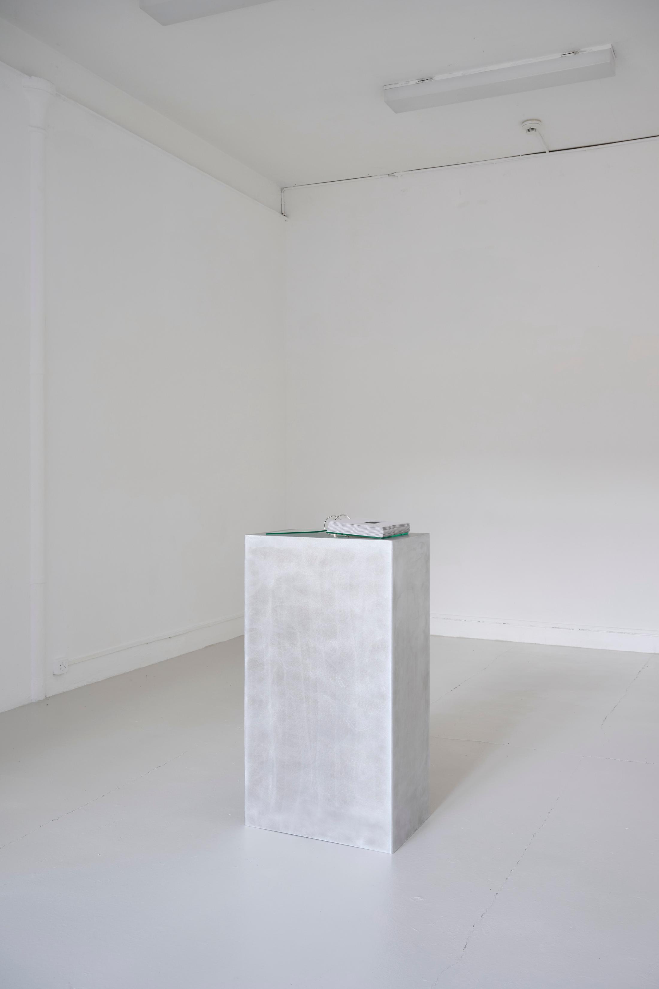 Exhibition View Solo Show Pauline Cordier «Holding Time; view on Pauline Cordier, 366, glass, printed on tracing paper, brushed aluminium, edition : 25 × 20 × 4 cm, base : 100 × 55 × 35 cm, 2024» at andata ritorno - laboratoire d'art contemporain, Geneva, 2024 / Photo: Loïc Herin / Courtesy: The artist and andata ritorno - laboratoire d'art contemporain