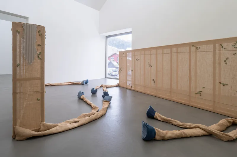 Exhibition View Group Show «Plattform24; view on Virginie Sistek, Resurrection Ranch, 2024, Wood, burlap flap, jeans, wadding, plaster, paint, transfer sticker, butterfly clasp brooch, MP3 sound chip module, paper, 660 x 574 cm» at Kunstmuseum Kunsthalle Appenzell, Appenzell, 2024 / Photo: Claude Barrault / Courtesy: The artists and Kunstmuseum Kunsthalle Appenzell
