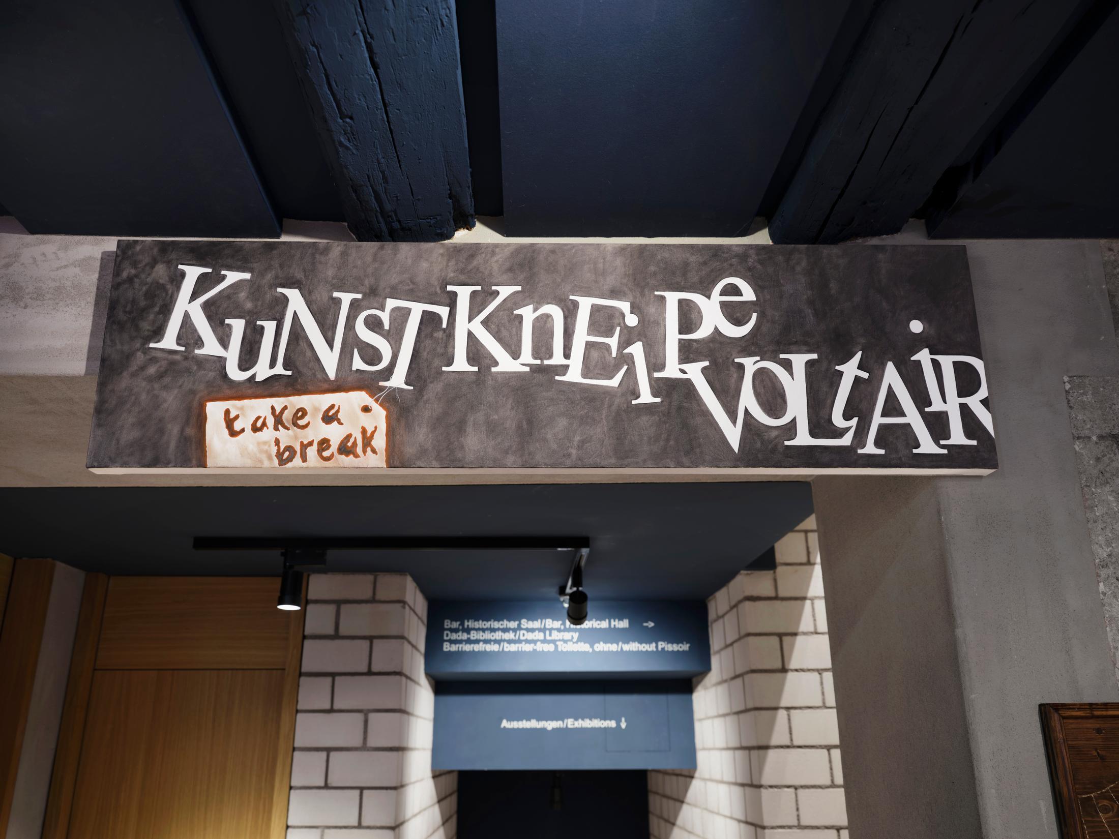 Exhibition View Group Show «The Red Herring; view on Camille Lütjens, Bar Sign (Kunst Kneipe Voltaire), 2024» at Cabaret Voltaire Artists’ Bar, Zurich, 2025 / Photo: Philipp Hänger / Courtesy: the artists and Cabaret Voltaire