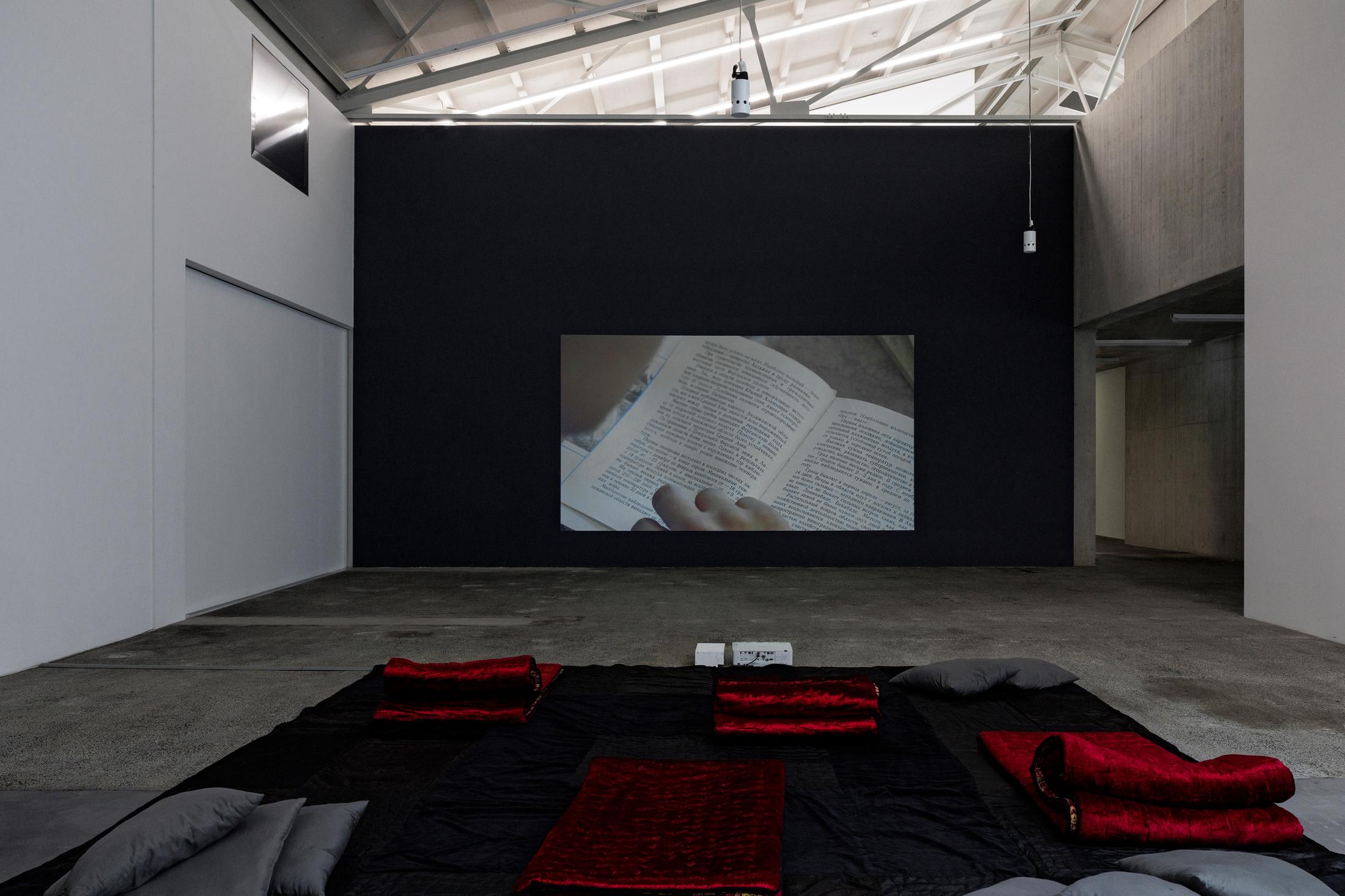 Exhibition View Group Show «In Between Between No More and Not Yet; view on Saodat Ismailova, 18000 Worlds, 2023, Video, Colour, Clay, 31’, Letters, 2014-2019, Photo Paper, 3 Photos ca. 39 x 29 cm, 1 Photo ca. 38 x 40 cm , Black kurpa, 2017, Plea 4 kurpacha, 2021, Cotton, Synthetic Fabric, 5 x 5 m, 3 x 189 m, Fear, 2014-2019. Photo Paper, 6 Collages je ca. 19 x 30 cm» at Kunsthaus Baselland, 2024 / Photo: Gina Folly / Courtesy: the artist and Kunsthaus Baselland