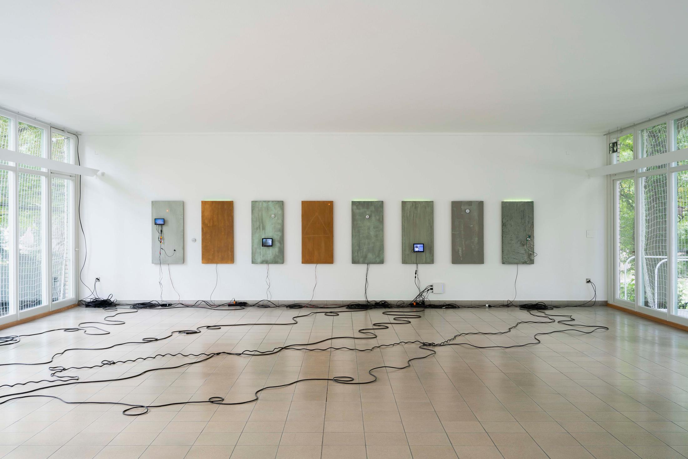 Exhibition View Group Show «Im Volksgarten; view on Julia Scher, Delta, 2018, concrete mix coated insulation boards, hygrometer, camera, hard disk, LED, cables, 8 parts each 120 x 60 cm» at Kunsthaus Glarus, Glarus, 2020 / Photo: Gunnar Meier / Courtesy: the artist and DREI, Cologne / Esther Schipper, Berlin