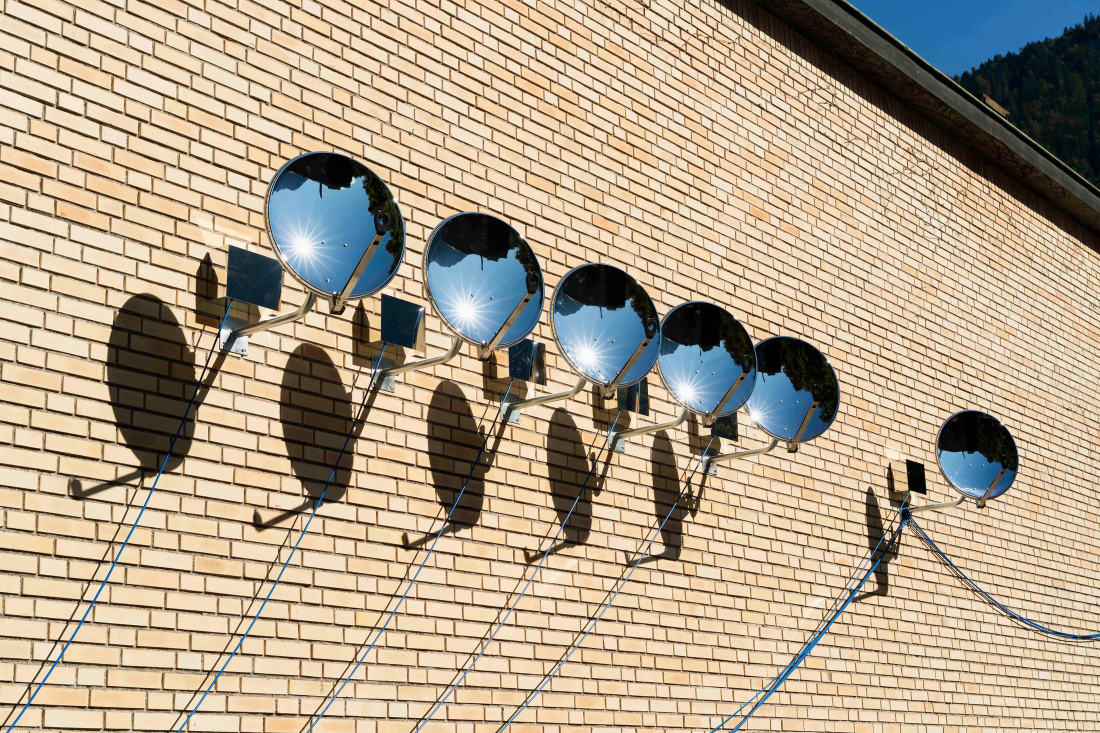 Exhibition View Group Show «Im Volksgarten; view on Rachal Bradley, Untitled, 2020, (detail), 10 chromed satellite dishes, 10 ionisers, aluminum di-bond housing, electrical wire cable and various hardware, dimensions varible» at Kunsthaus Glarus, Glarus, 2020 / Photo: Gunnar Meier / Courtesy: the artist and Galerie Gregor Staiger, Zurich