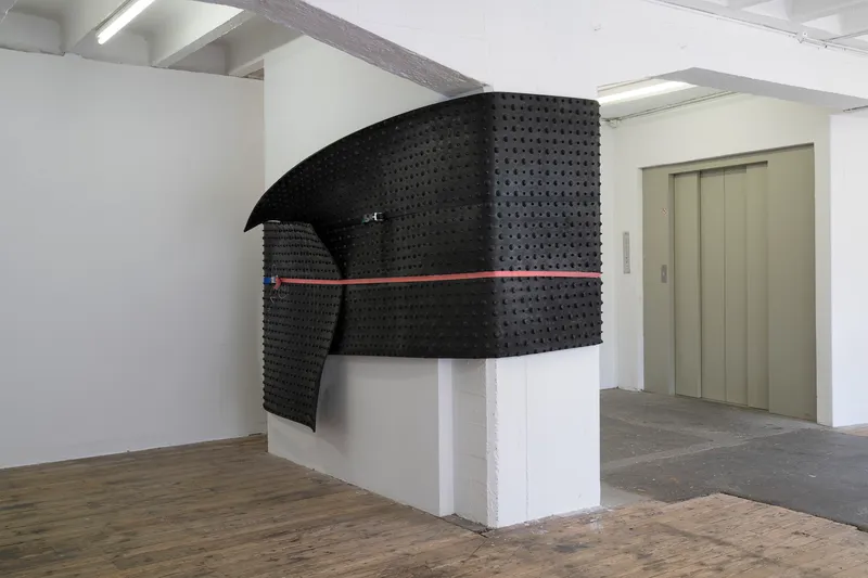 Exhibition View Group Show «Issue de secours; view on Val Minnig, Rubber coat, 2017, Kälber Neugummi Rollmatte schwarz mit Noppen, SpanSet» at Binz39, Zürich, 2021 / Photo: Claude Barrault / Courtesy: the artists and Binz39