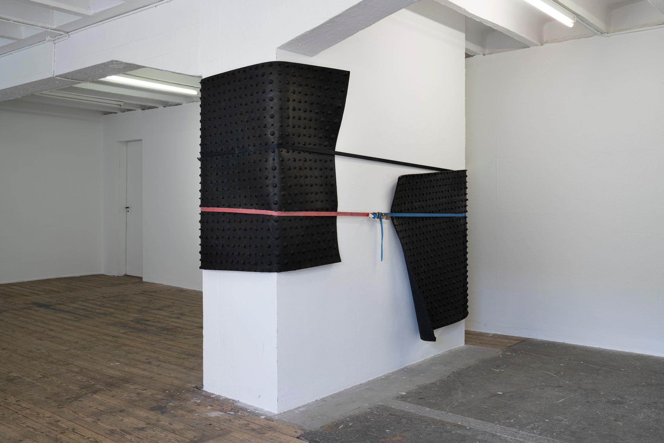 Exhibition View Group Show «Issue de secours; view on Val Minnig, Rubber coat, 2017, Kälber Neugummi Rollmatte schwarz mit Noppen, SpanSet» at Binz39, Zürich, 2021 / Photo: Claude Barrault / Courtesy: the artists and Binz39