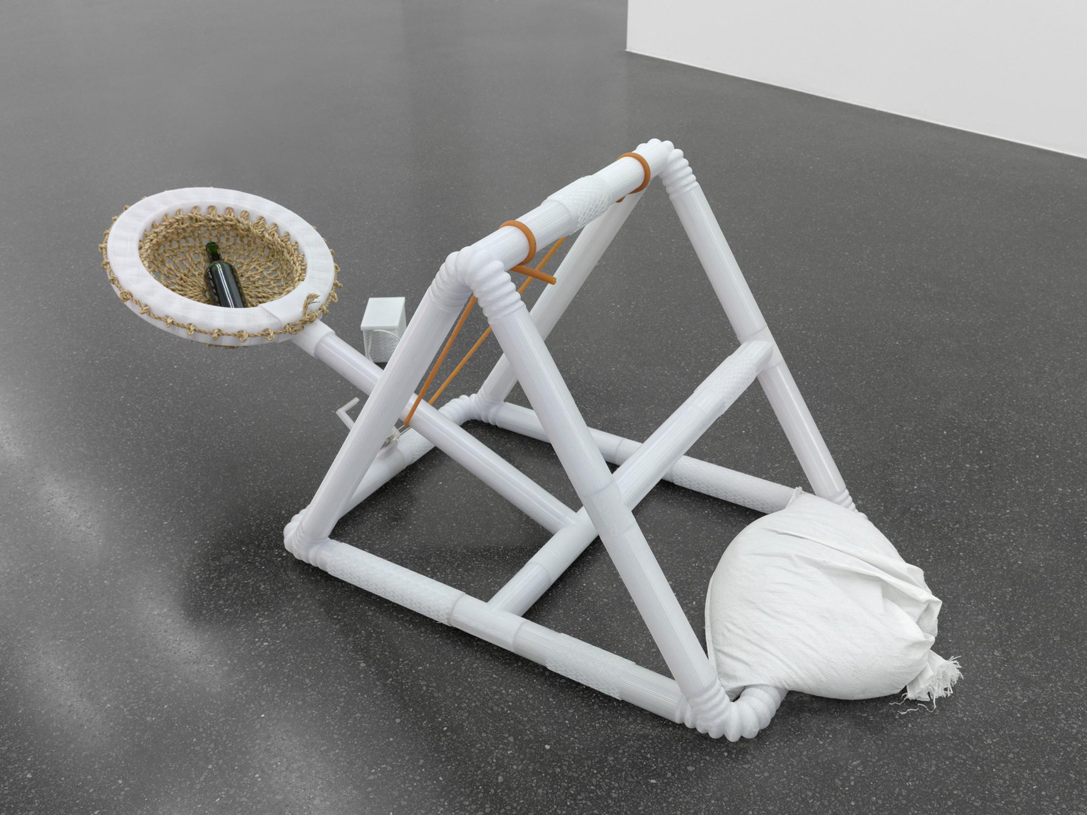 Exhibition View Kaspar Müller Solo Show «In and Out; view on Kaspar Müller & Iacopo Spini, Bottle Catapult, 2020, 3D fused filament fabrication, straw basket pattern, wine bottle, electronic motorized parts, sand bag, elastic band, 67 x 74 x 180 cm» at Galerie Francesca Pia, Zurich, 2020 / Photo: Annik Wetter / Courtesy: the artist and Galerie Francesca Pia