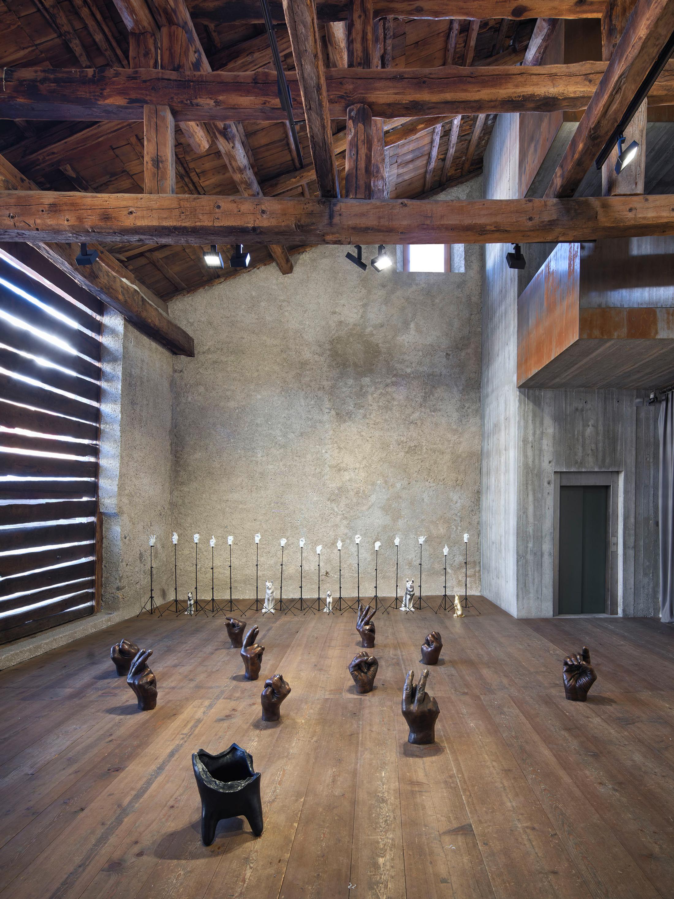 Exhibition View Kemang Wa Lehulere Solo Show «Where Did the Sky Go?; view on Kemang Wa Lehulere, Where Did the Sky Go?, 2020, 16 bronze life size hands on 16 music stands, 10 bronze large hands, bronze dog head, size variable» at Galerie Tschudi, Zuoz, Engadin, 2020 / Photo: Ralph Feiner / Courtesy: the artist and Galerie Tschudi