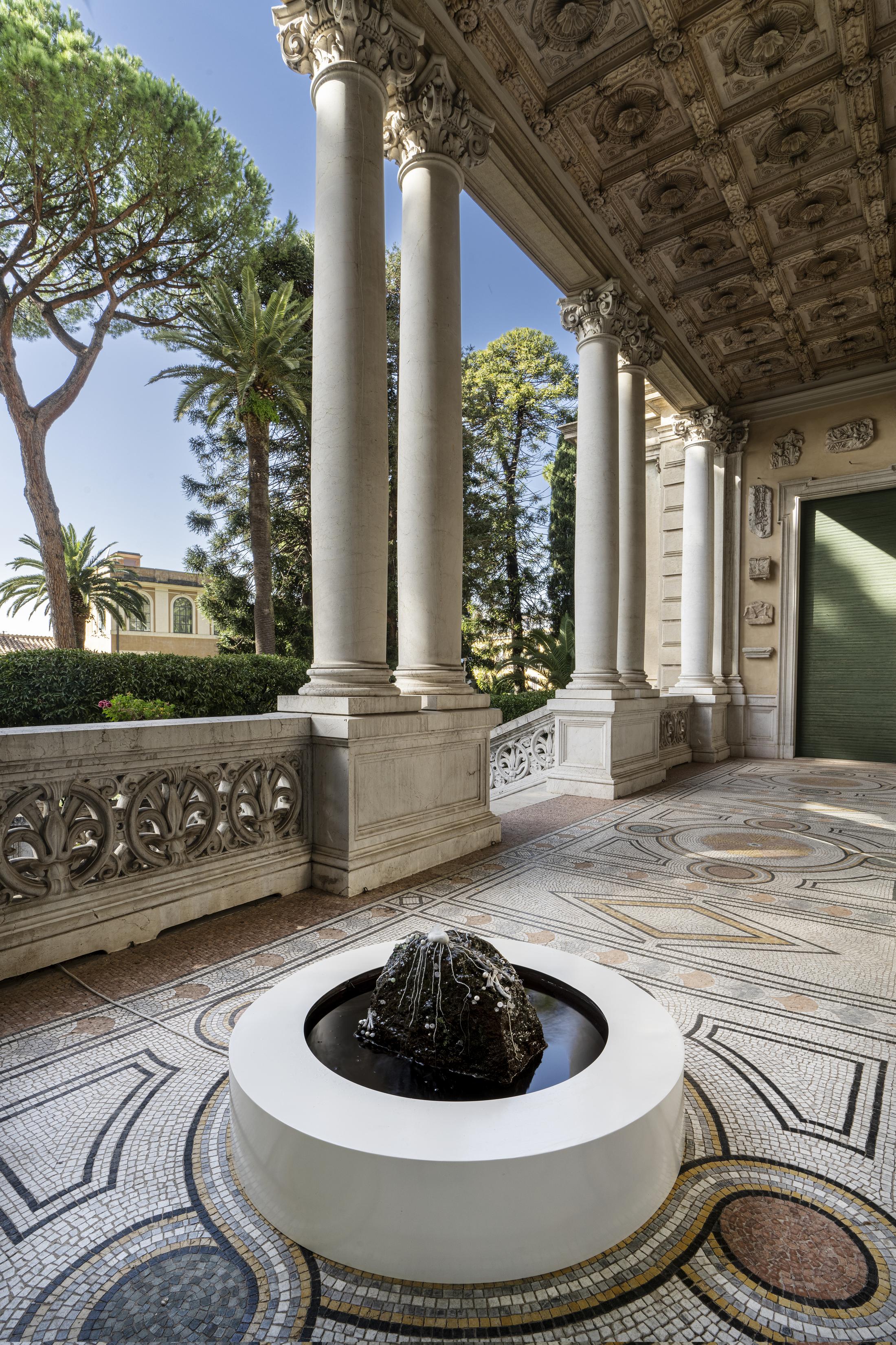 Exhibition View Group Show «L'arcobaleno riposa sulla strada; view on ou Masduraud, Spit kiss from earth, 2022, marble, tuff, quartz, crystal, amethyst, serpentine, agate, carnelian, malachite, oyster pearls, glass pearls, bones, enamelled steel, pump, water, 110 × 110 × 64 cm» at Istituto Svizzero, Rome, 2022-2023 / Photo: OKNOstudio, Ela Bialkowska / Courtesy: the artist and Istituto Svizzero